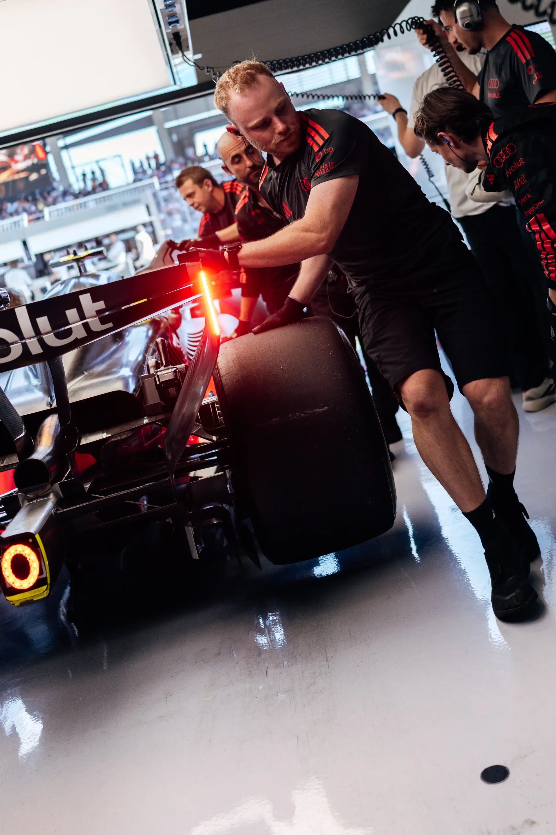 Audi Revolut F1® Team mechanics push the Audi R26 through the garage during Qualifying at the Austrian Grand Prix in Spielberg.