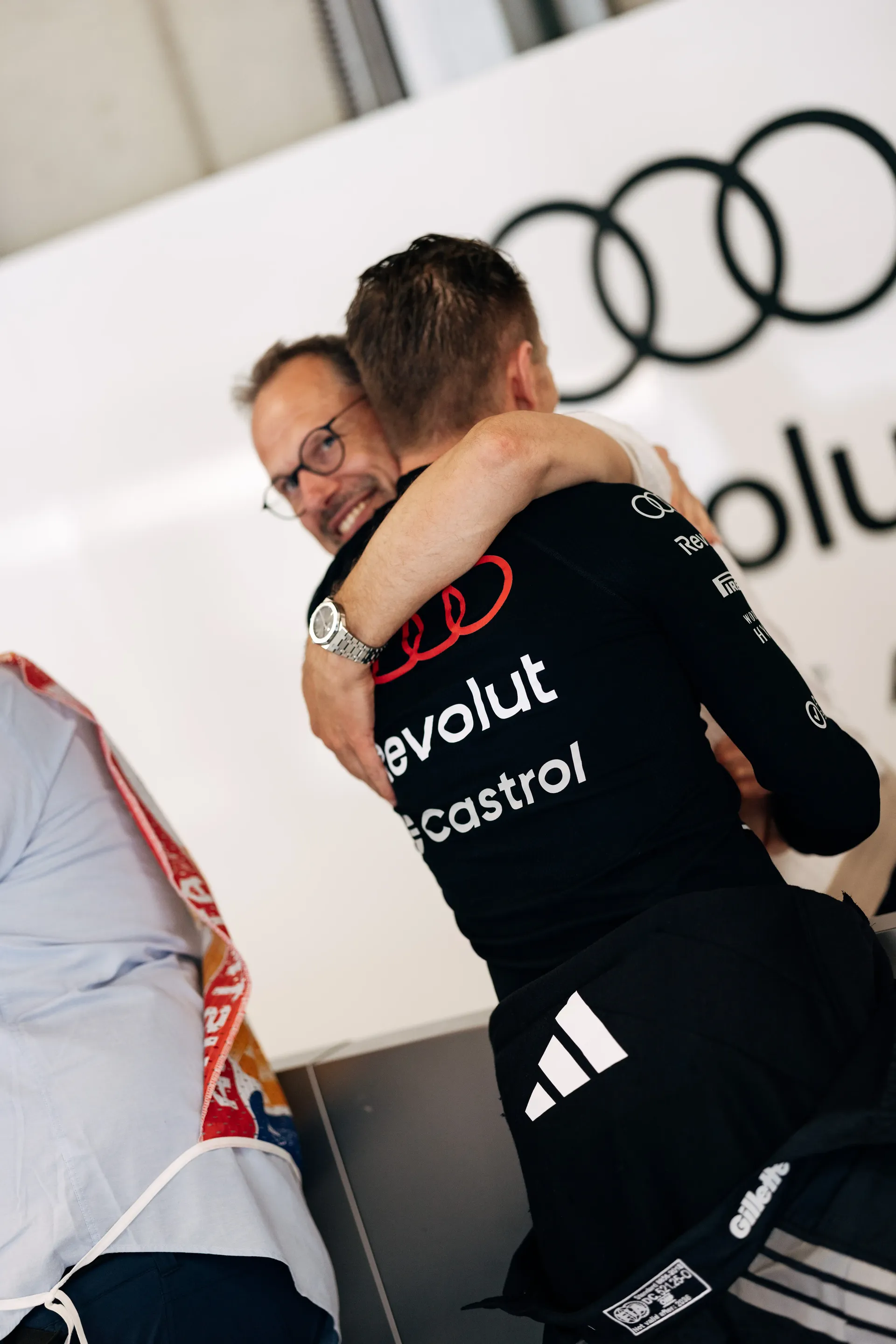 Nico Hulkenberg driver at the Audi Revolut F1® and mechanics share a celebratory hug inside the garage on race day at Spielberg.