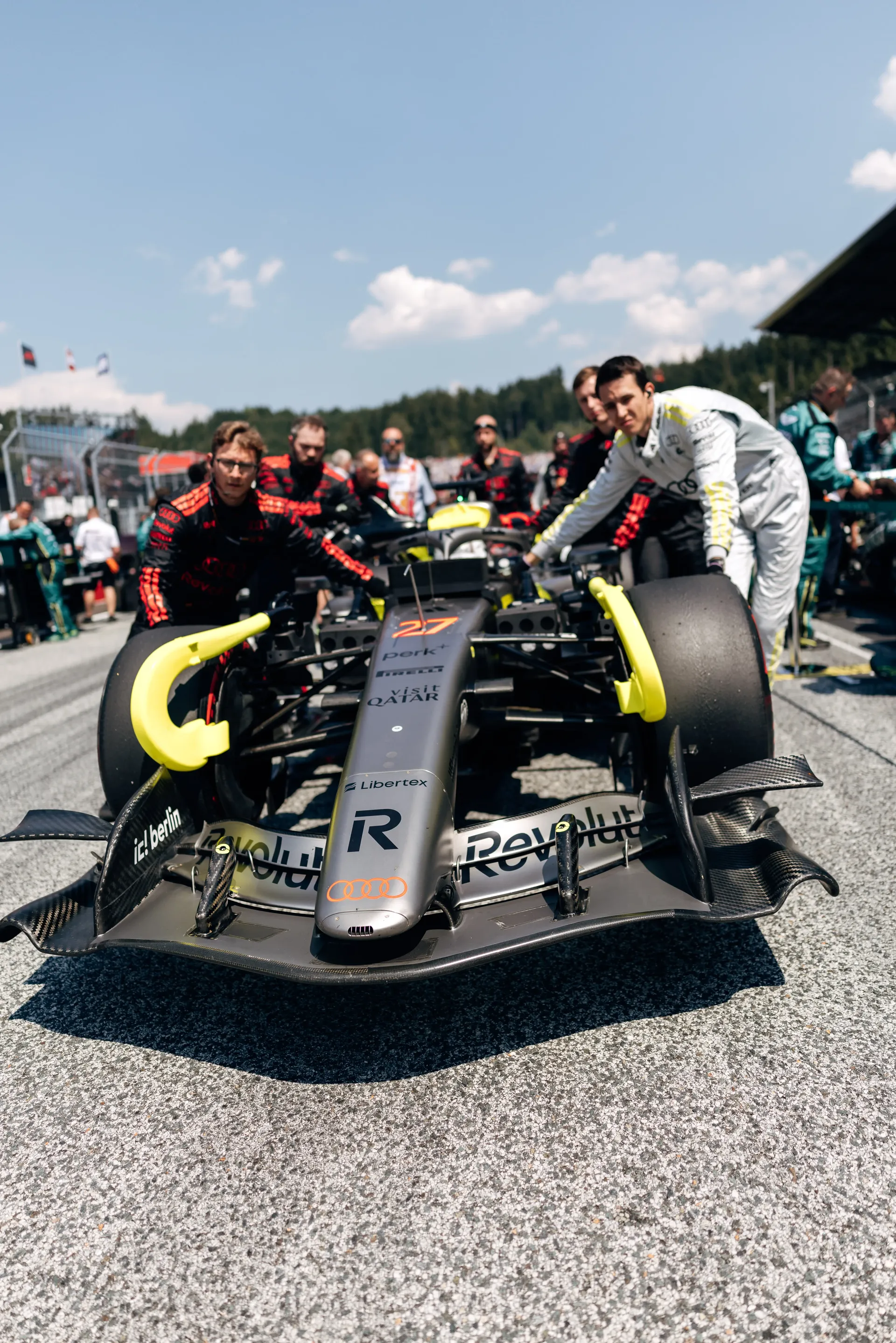 Audi Revolut F1® Team mechanics push the Audi R26 into position on the Spielberg starting grid before the race.