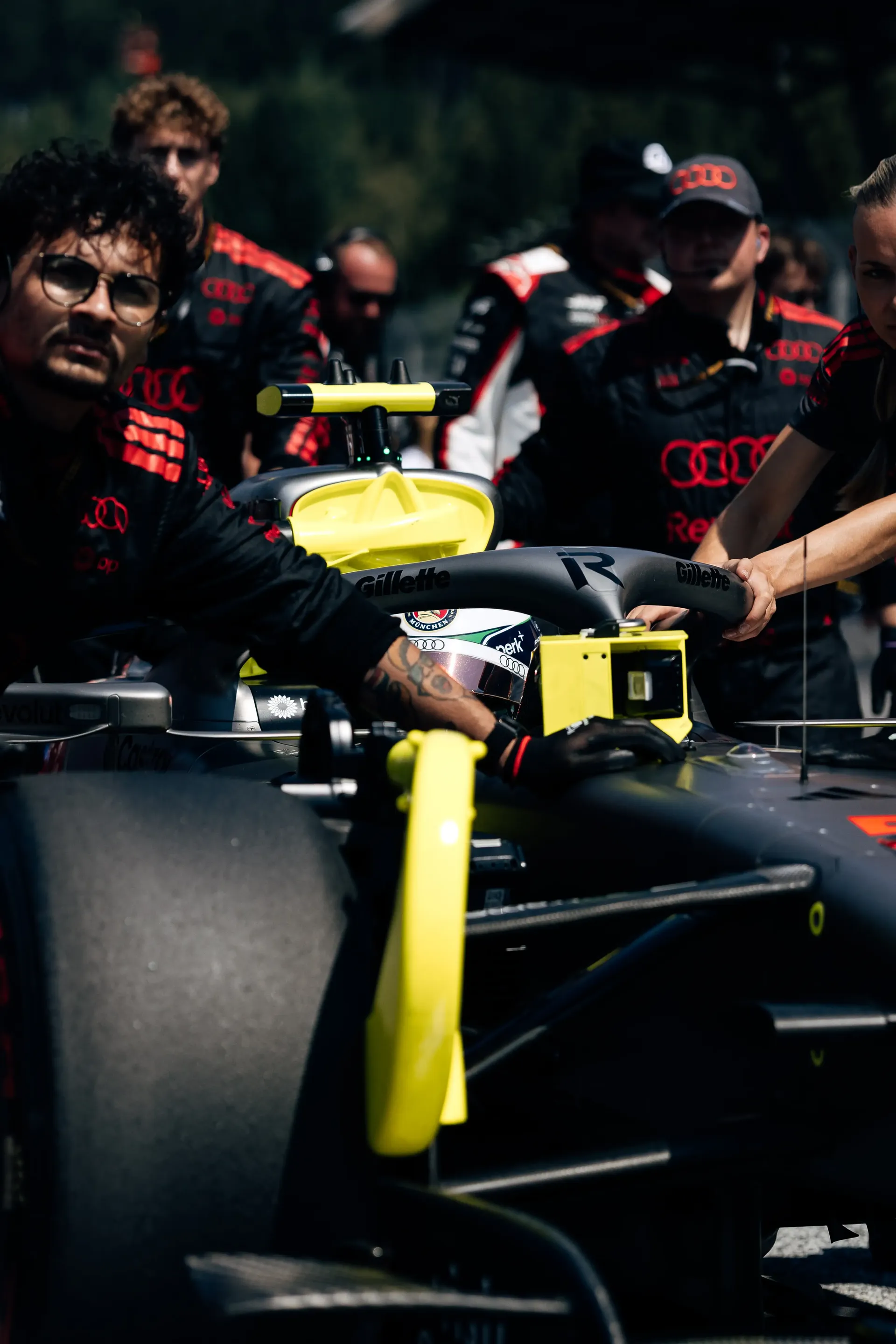 Front three-quarter view of the Audi R26 surrounded by mechanics on the starting grid.