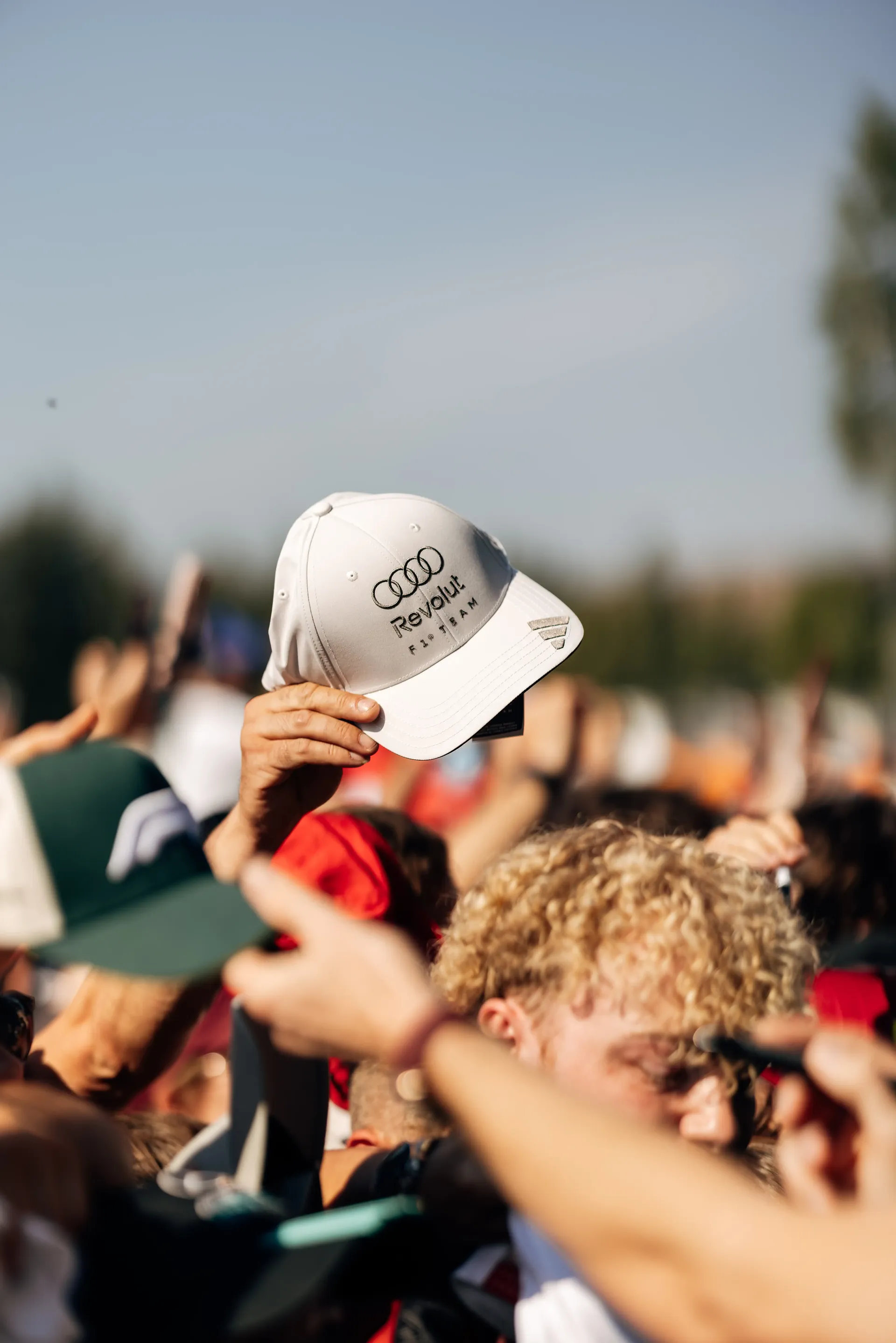 Fans hold Audi Revolut F1® Team caps as Nico Hulkenberg signs autographs before the Formula 1® Austrian Grand Prix in Spielberg before the race.