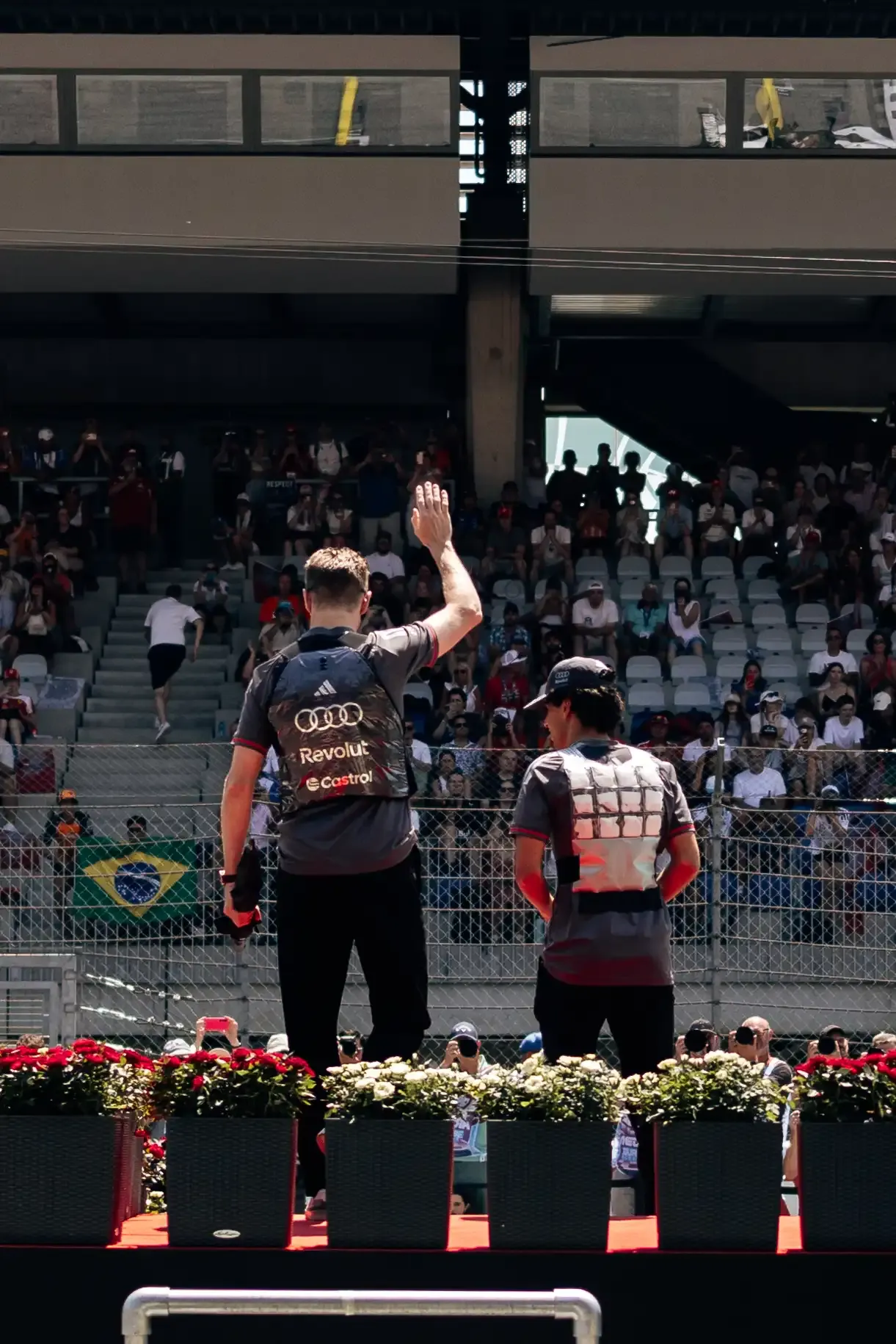 Nico Hulkenberg and Gabriel Bortoleto wave to fans during the Formula 1 Drivers' Parade before the Austrian Grand Prix in Spielberg.
