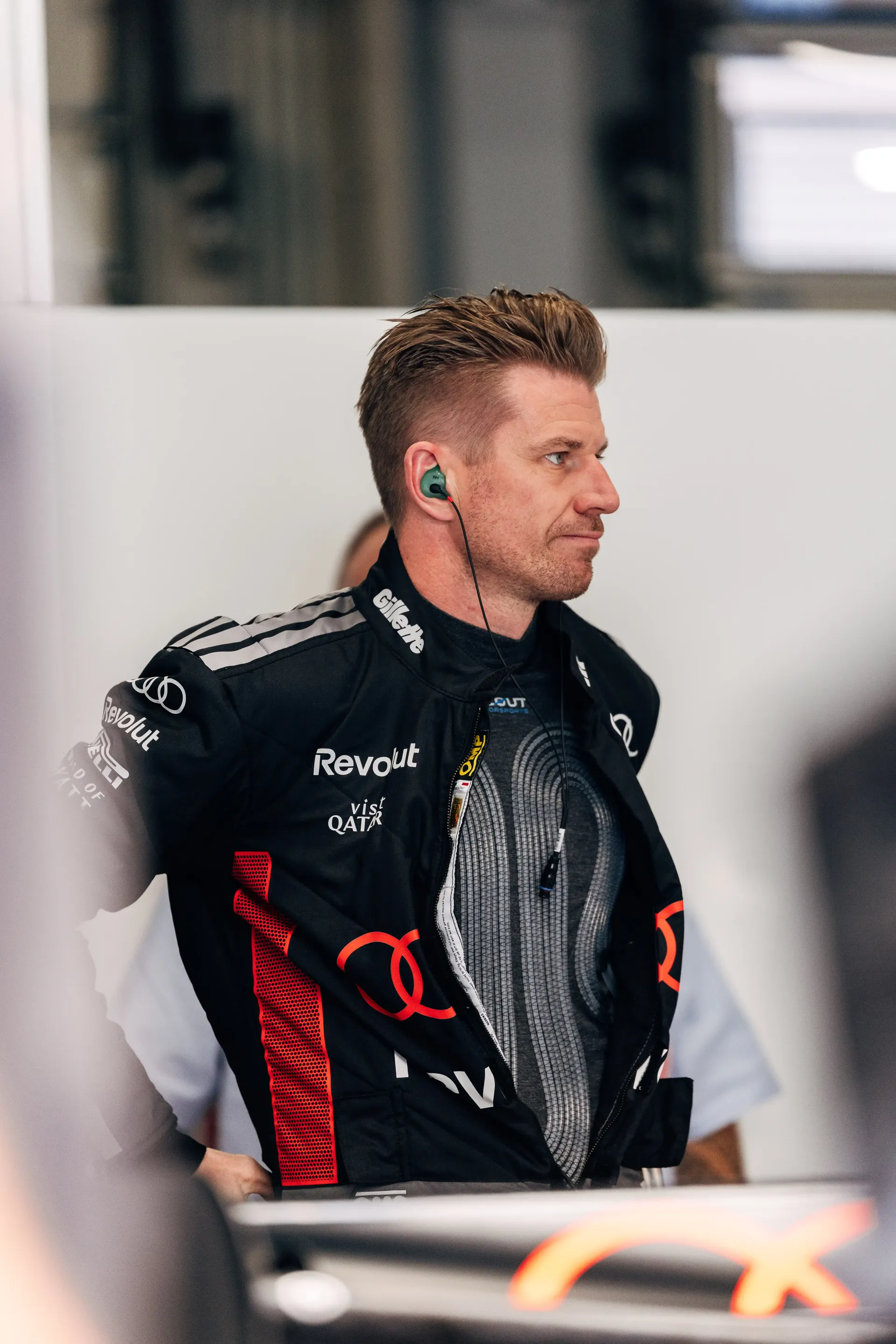 Side profile of Nico Hulkneberg driver at the Audi Revolut F1® Team during FP1 at Spielberg, standing in the garage area while focused ahead of track sessions.