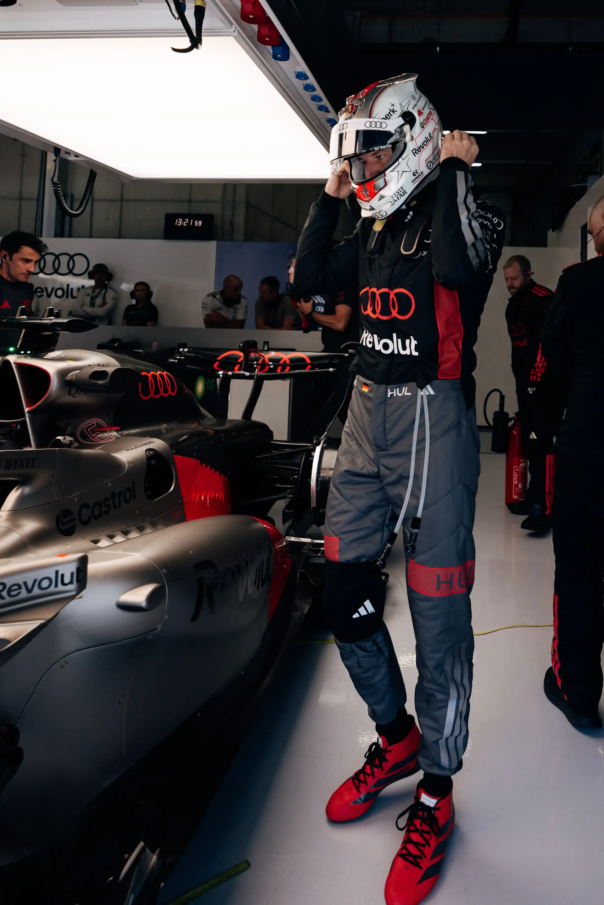 Audi Revolut F1® Team driver Nico Hulkenberg standing beside the car in the garage during FP1 at Spielberg, fully suited and ready for the opening practice session of the Austrian Grand Prix.