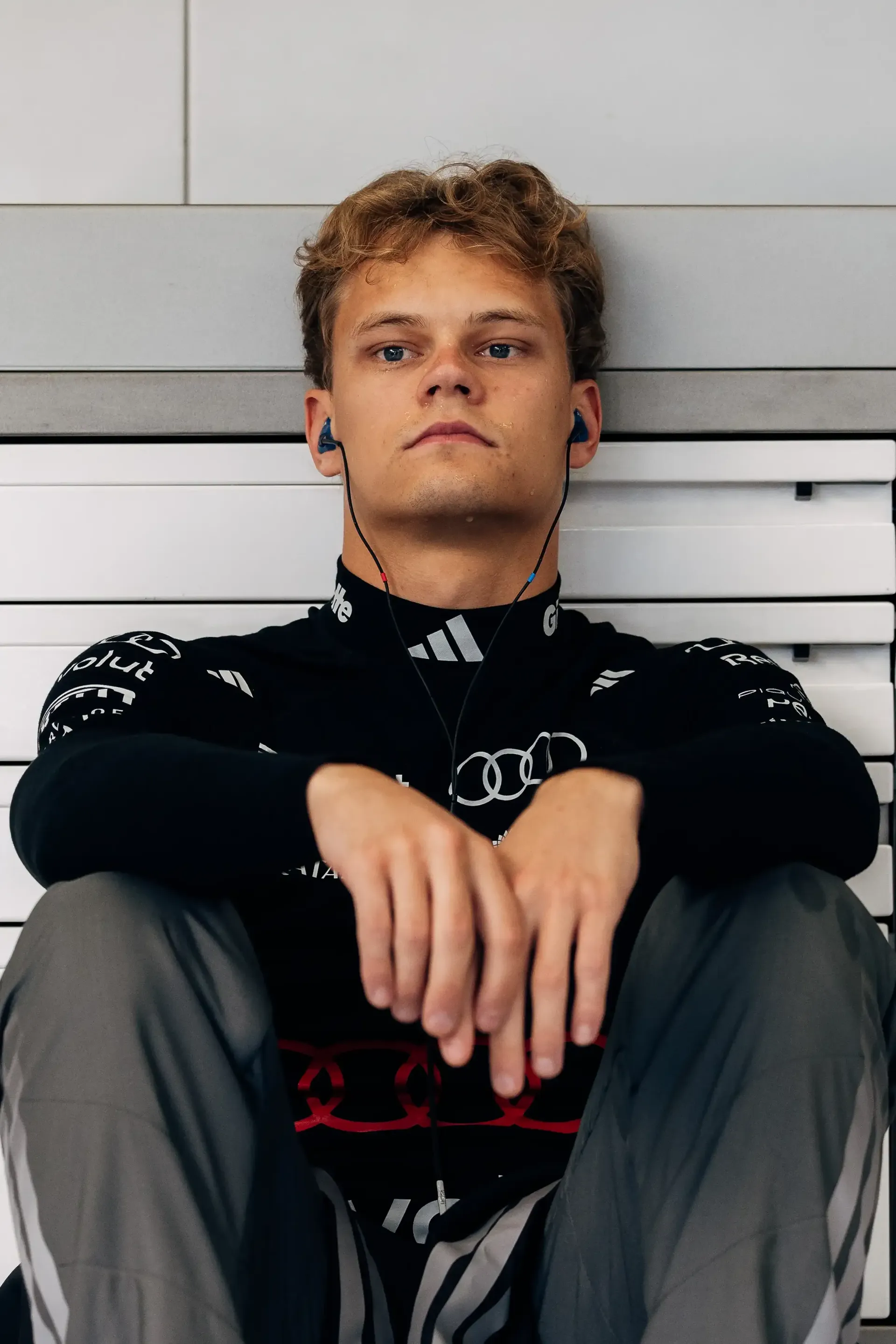 Portrait of Paul Aron driver at the Audi Revolut F1® Team driver during FP1 in Spielberg, listening to music while preparing for the opening practice session of the Austrian Grand Prix weekend.