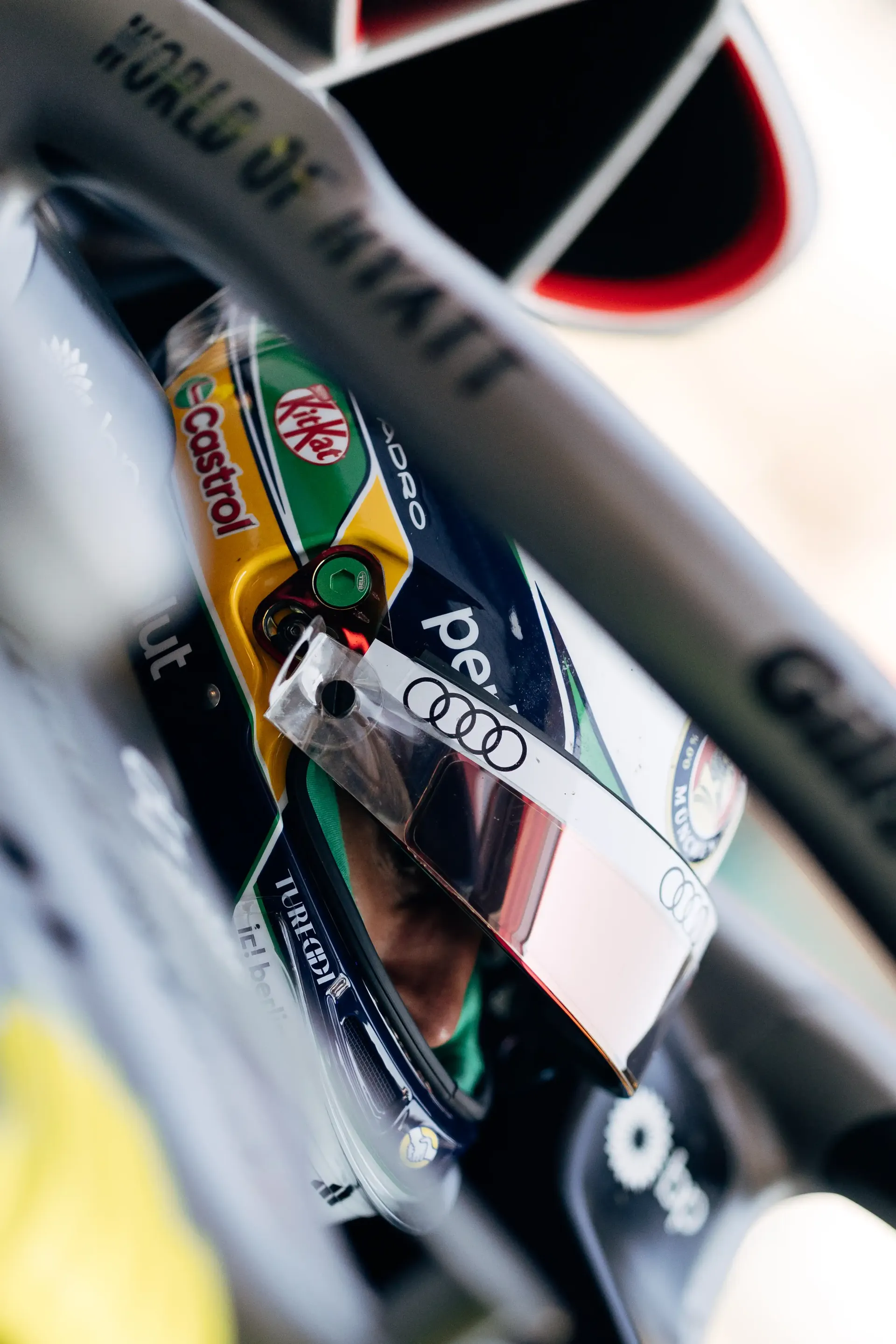Close-up of a helmeted Audi Revolut F1® Team driver Gabriel Bortoleto inside the cockpit, viewed through the halo during FP2.