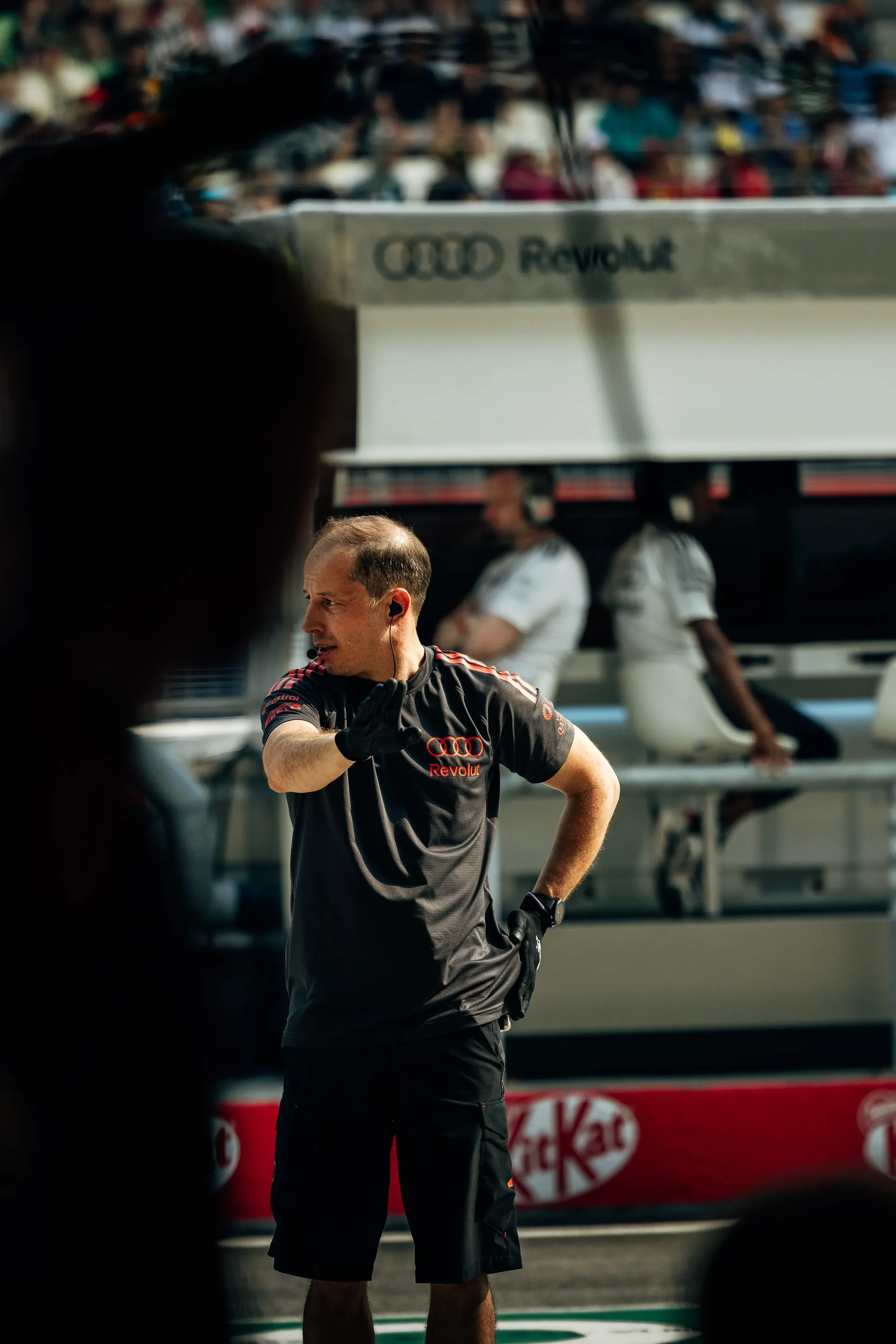 Close up of Audi Revolut F1® Team team mechanic in front of the garage giving instructions