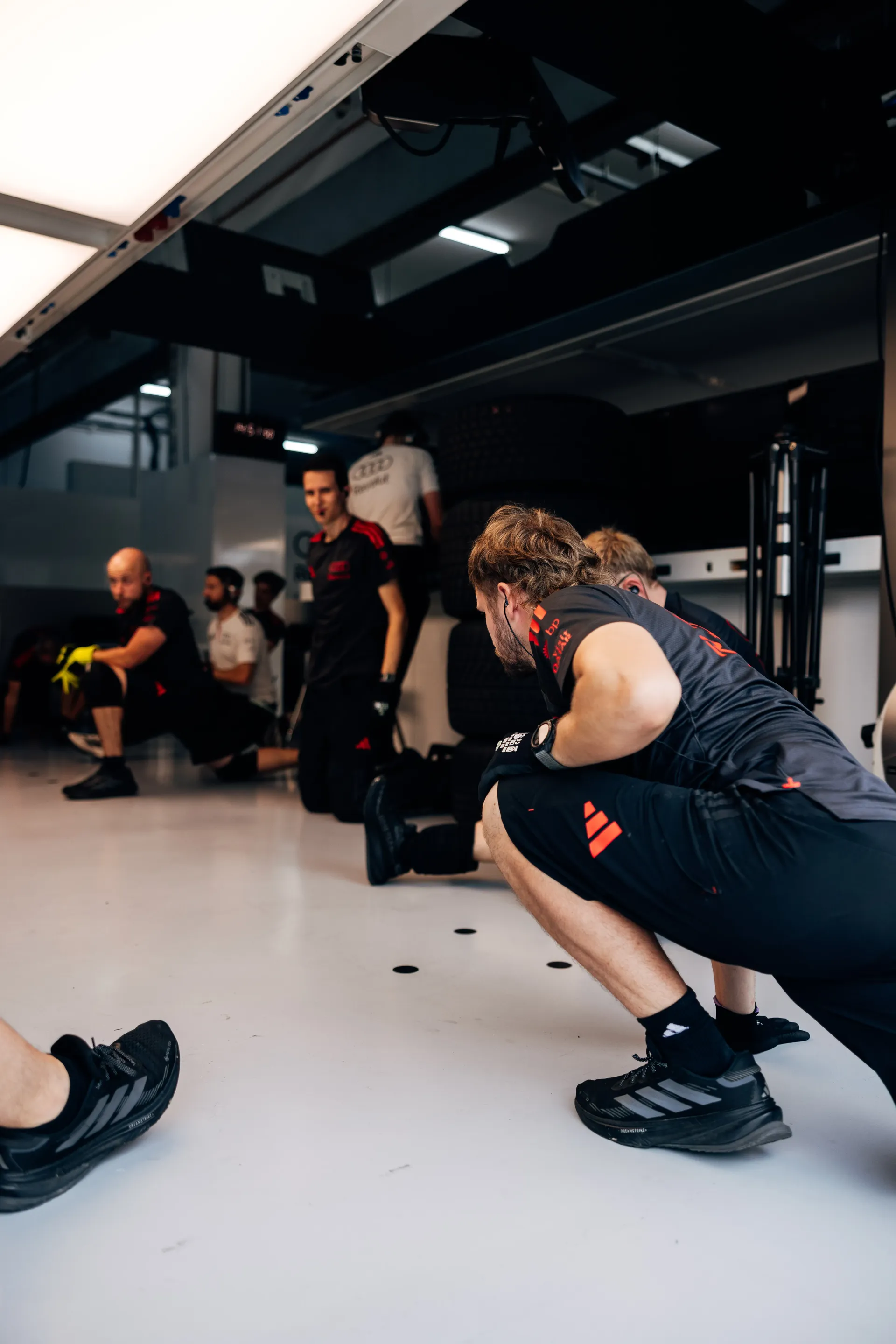 Audi Revolut F1® Team mechanic stretching in the garage