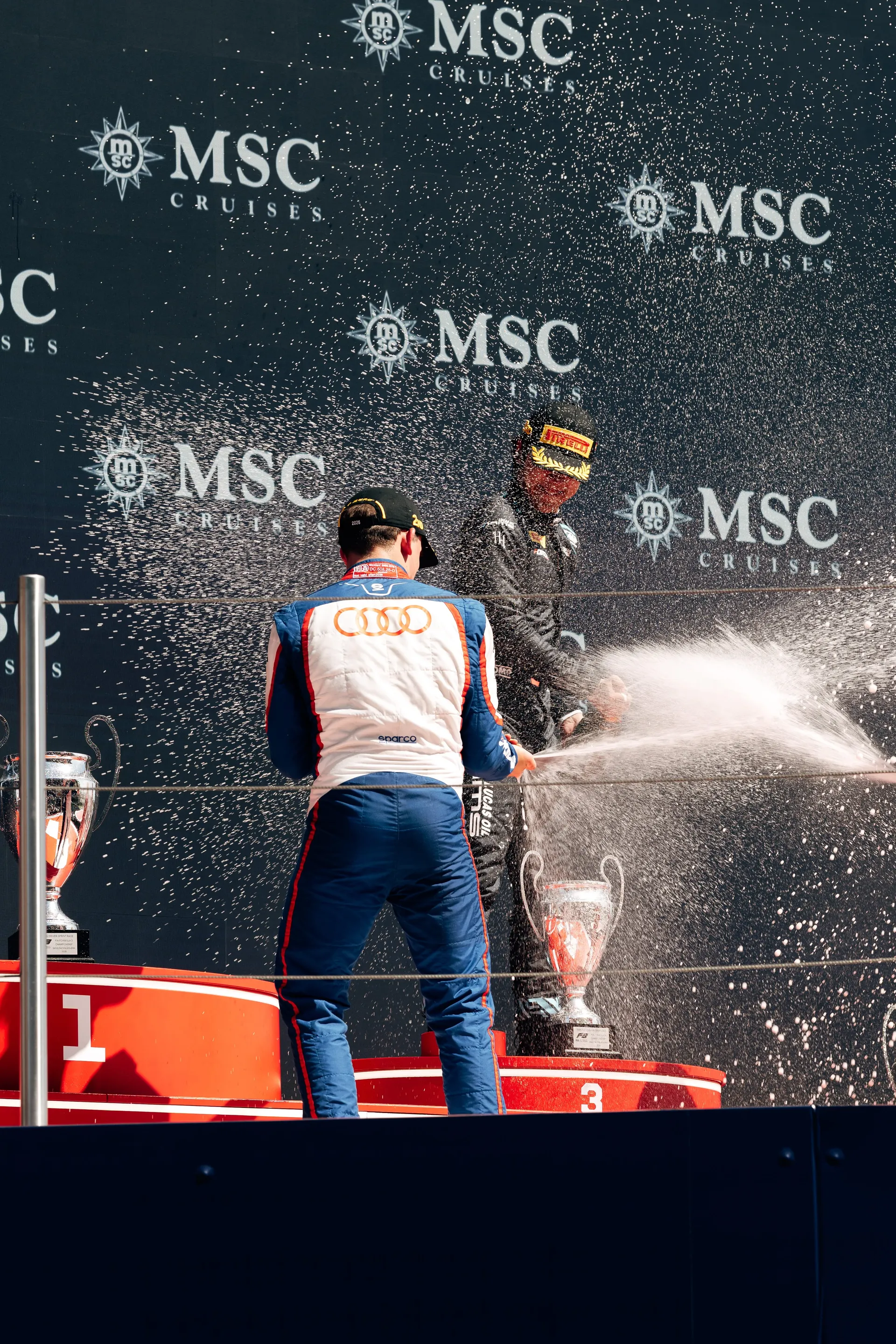 Freddie Slater spraying champagne on the podium in Barcelona, seen from behind
