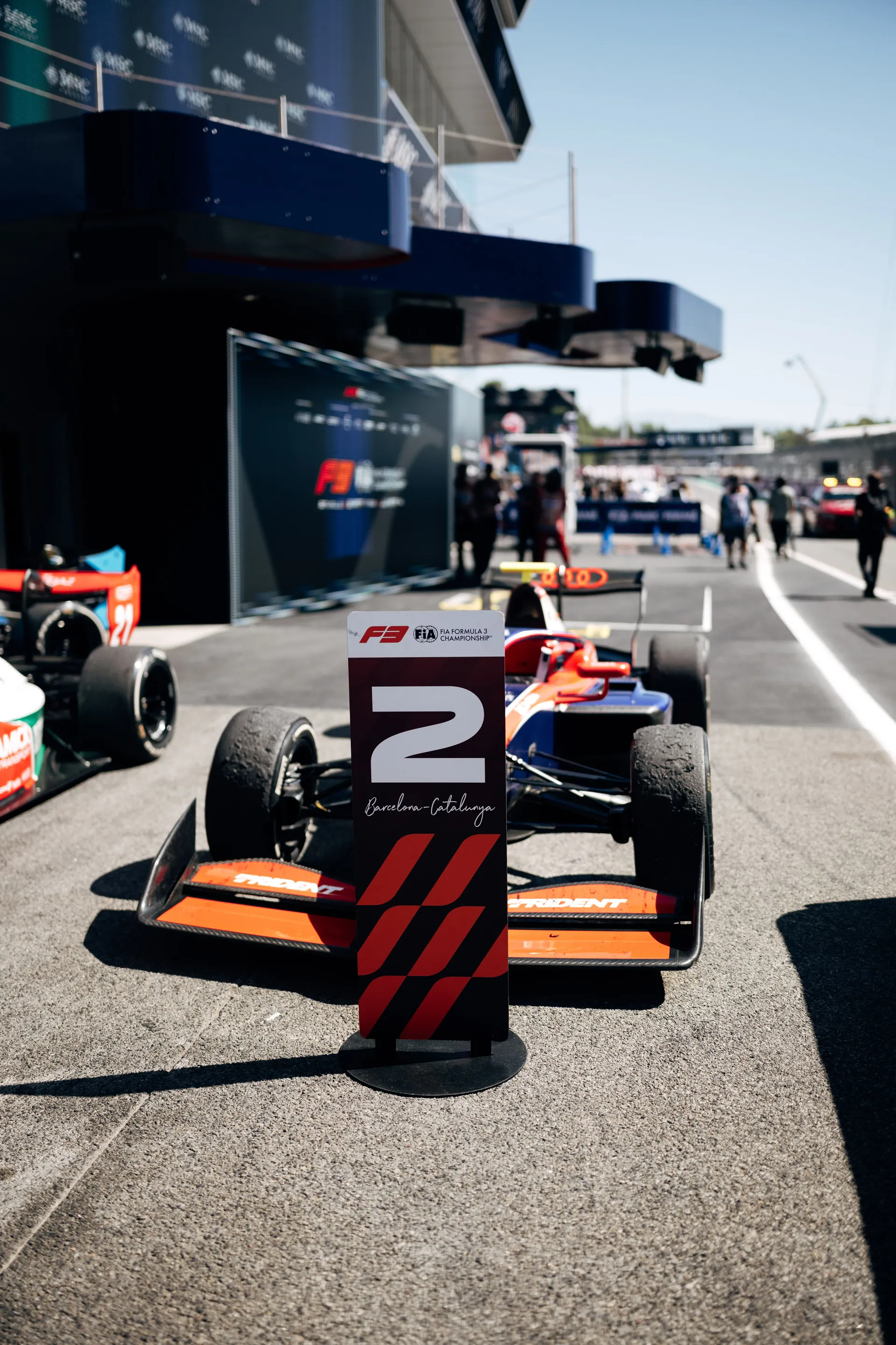F3 car parked in the Barcelona pit lane with a position marker showing P2, highlighting the grid setup before the sprint race.