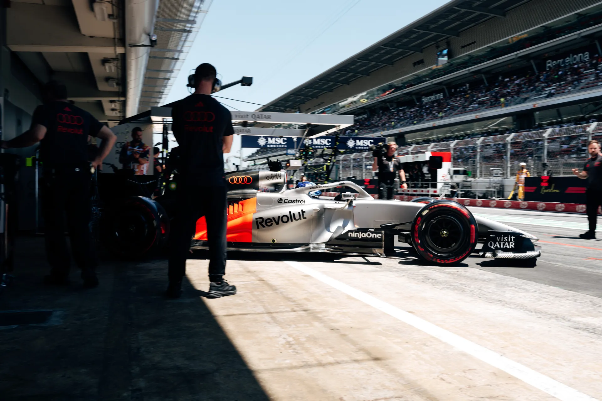Audi Revolut F1® Team car number 5 exits the garage into the Barcelona pit lane with crew and cameras around