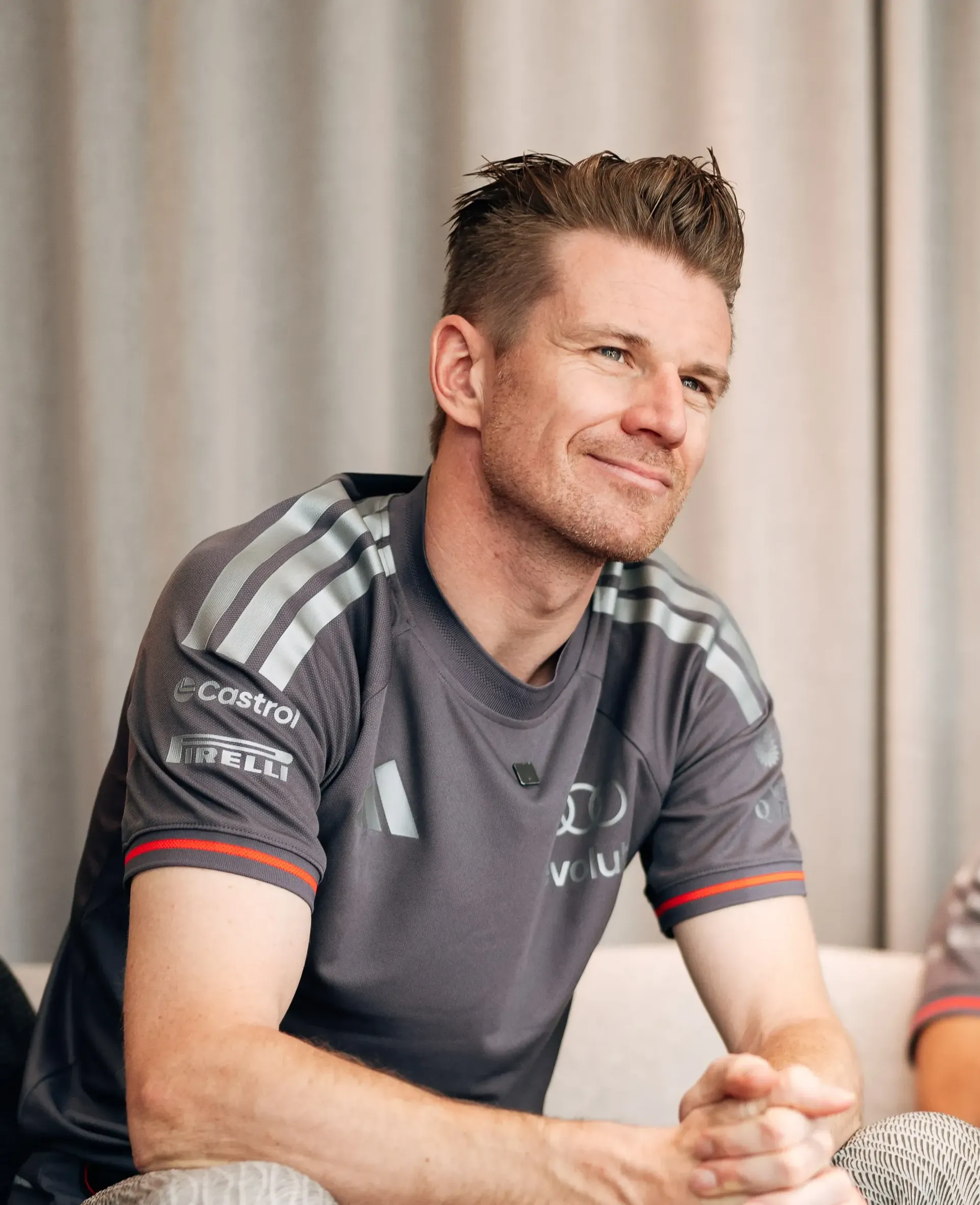Nico Hulkenberg driver at the Audi Revolut F1® Team in relaxed pose sitting on the couch next to Gabriel Bortoleto
