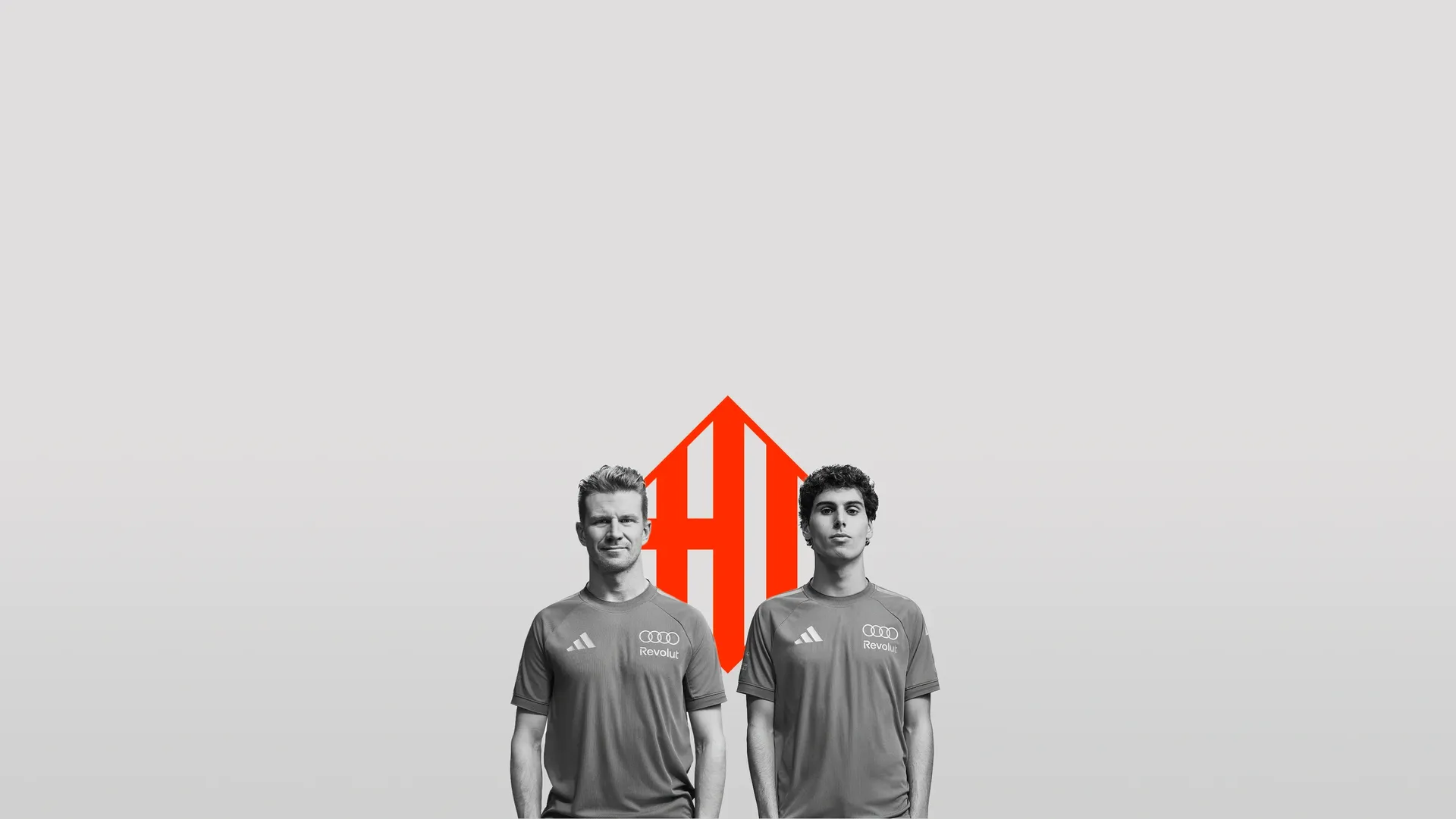 Nico Hulkenberg and Gabriel Bortoleto drivers at the Audi Revolut F1® Team standing side by side in relaxed pose in front of the Barcelona Flag