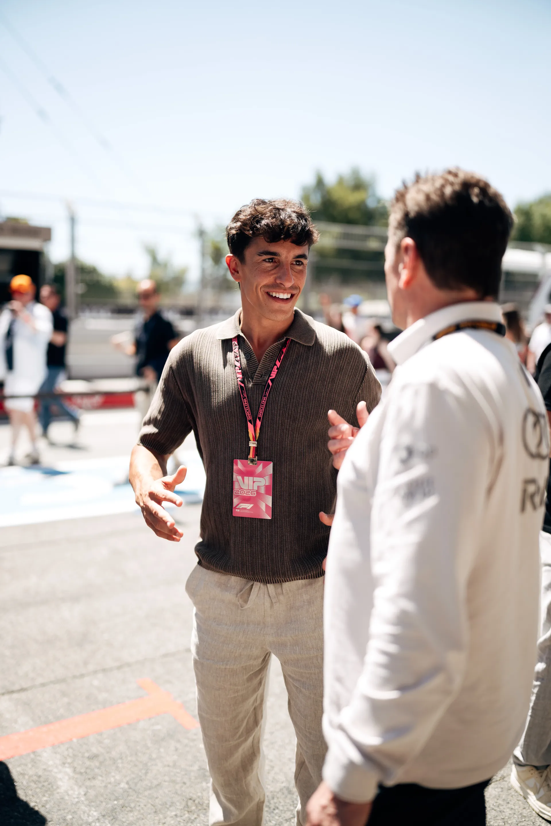 Marc Márquez wearing a VIP pass speaking with Allan McNish from Audi Revolut F1® Team on the Barcelona pit lane