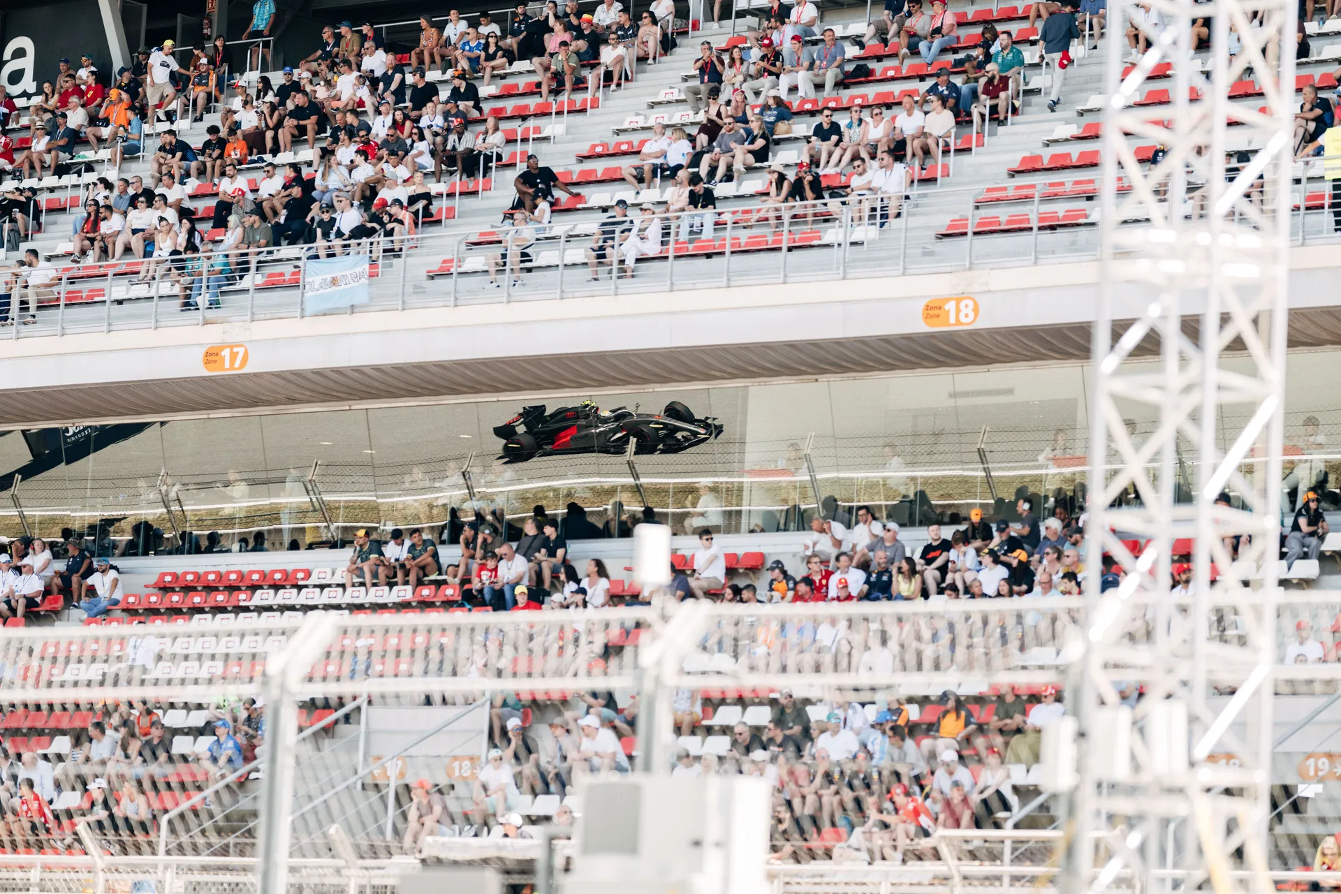 Audi Revolut F1® Team Formula One car driving past packed grandstands at Circuit de Barcelona Catalunya