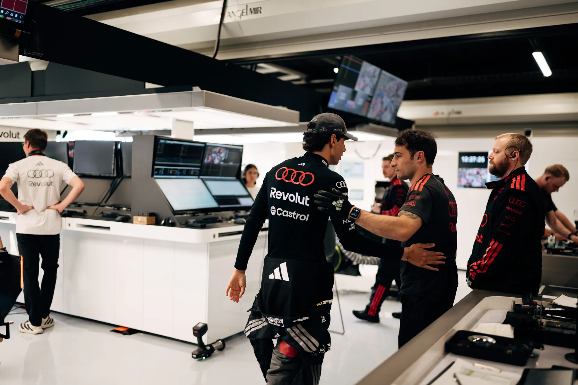 Gabriel Bortoleto entering the Audi Revolut F1® Team garage, greeted by a race engineer during pre-session preparations