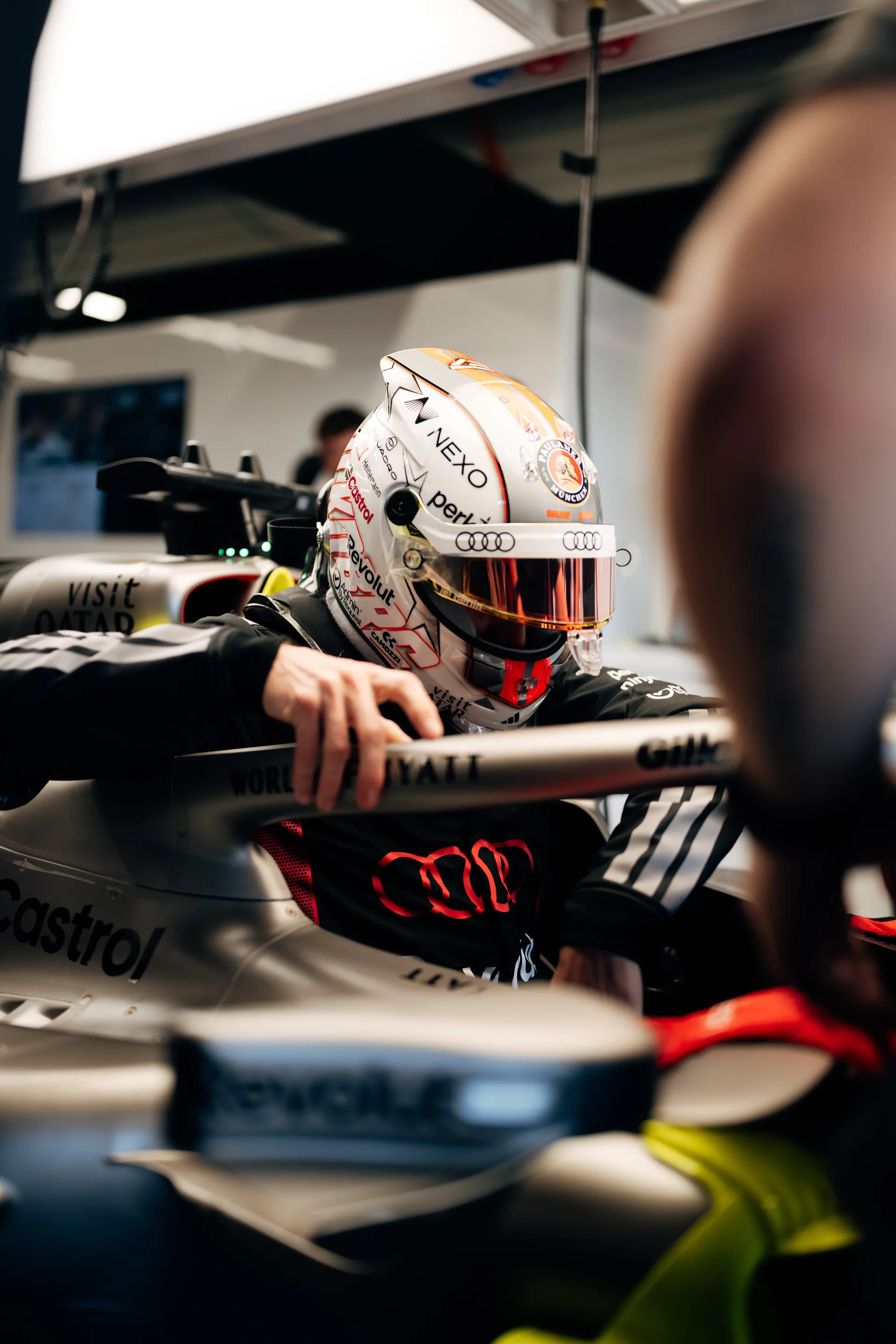 Nico Hulkenberg seated in the Audi Revolut F1® Team car inside the garage, adjusting his position before heading out