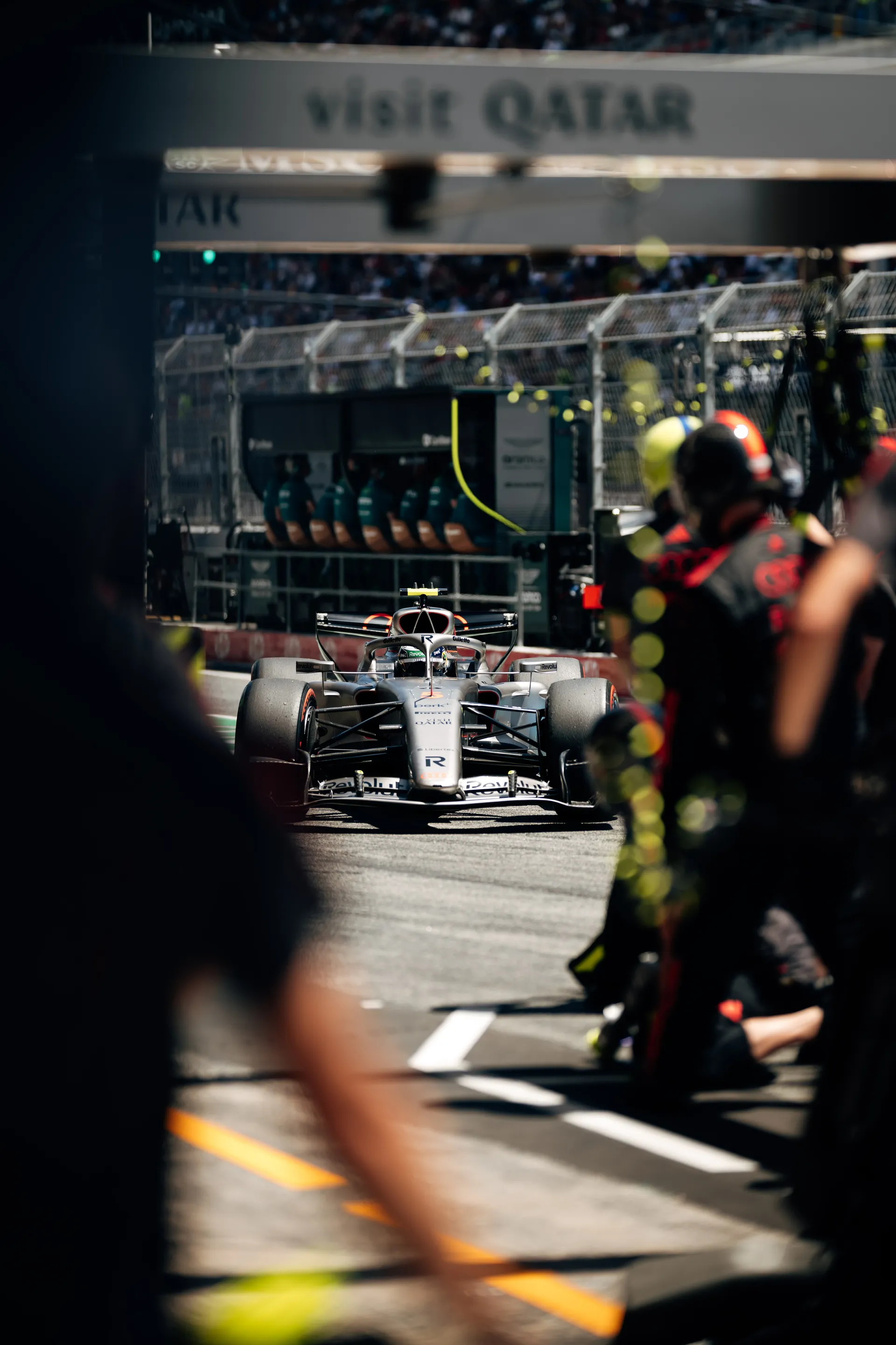 Audi Revolut F1® Team car lined up in the pit lane during a session in Barcelona, surrounded by mechanics and equipment