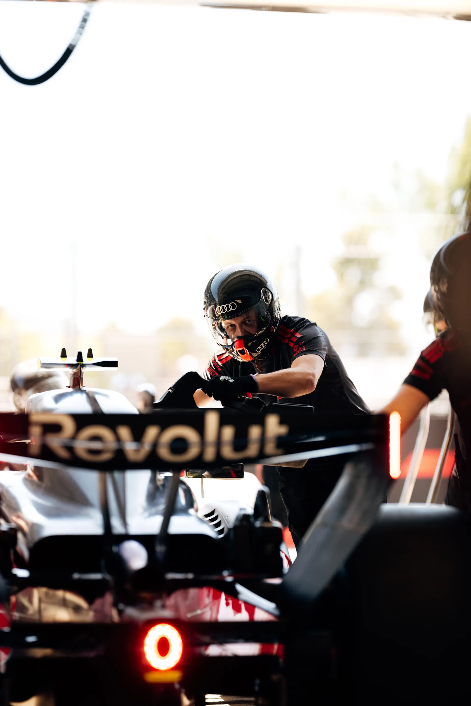 Audi Revolut F1® Team mechanics pushing the car out of the garage during a pit lane sequence in Barcelona