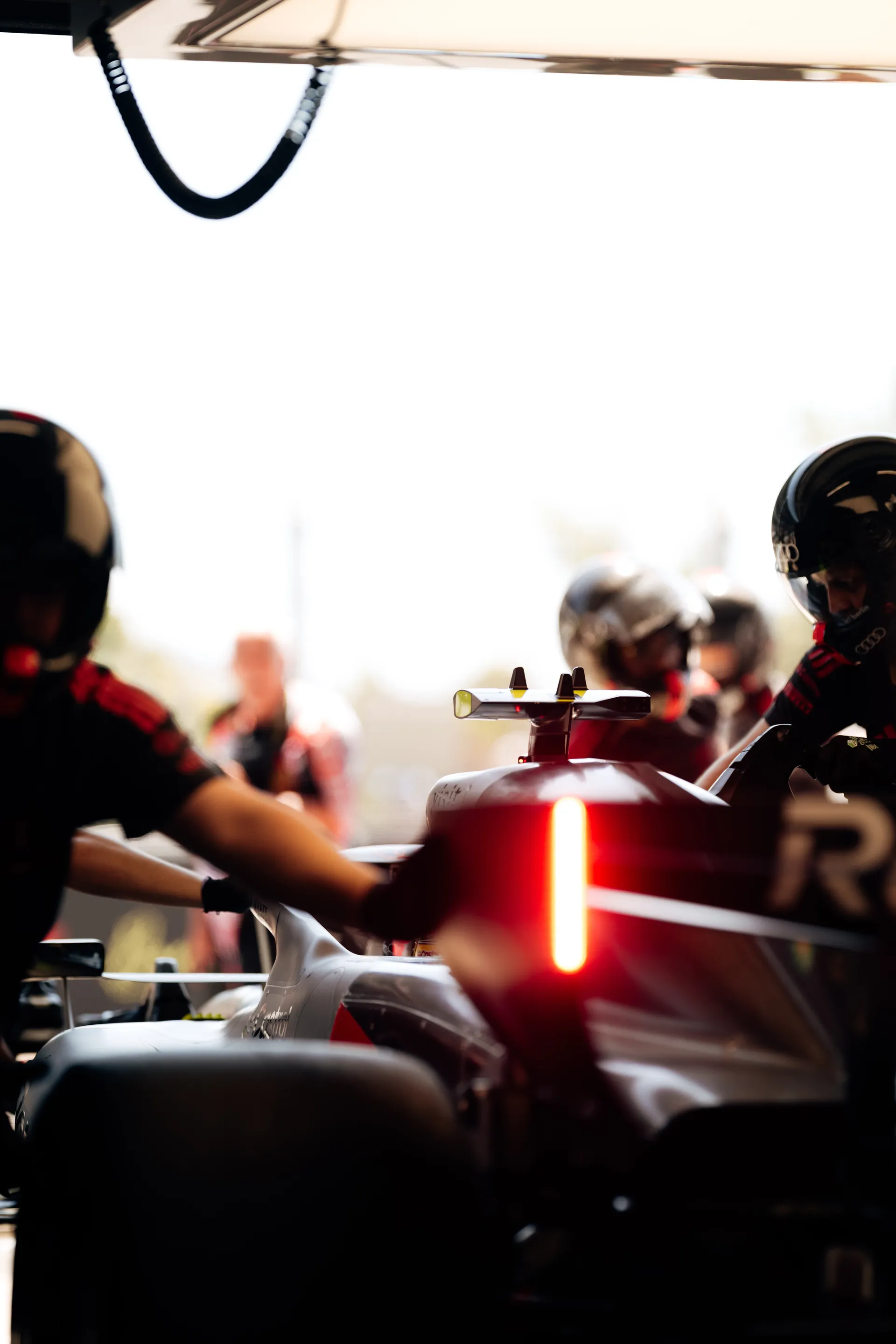 Wide shot of the Audi Revolut F1® Team garage with mechanics, equipment, and the car positioned near the pit exit