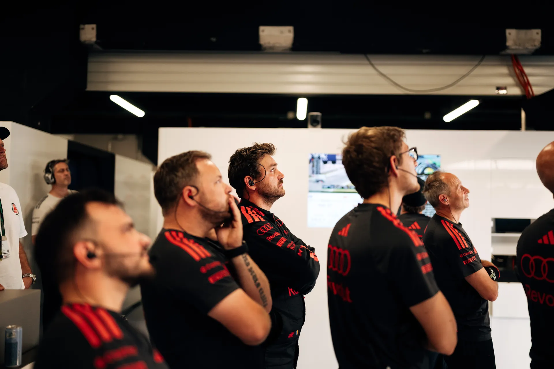 Audi Revolut F1® Team engineers wearing headsets watching live race data screens inside the Barcelona garage during qualifying