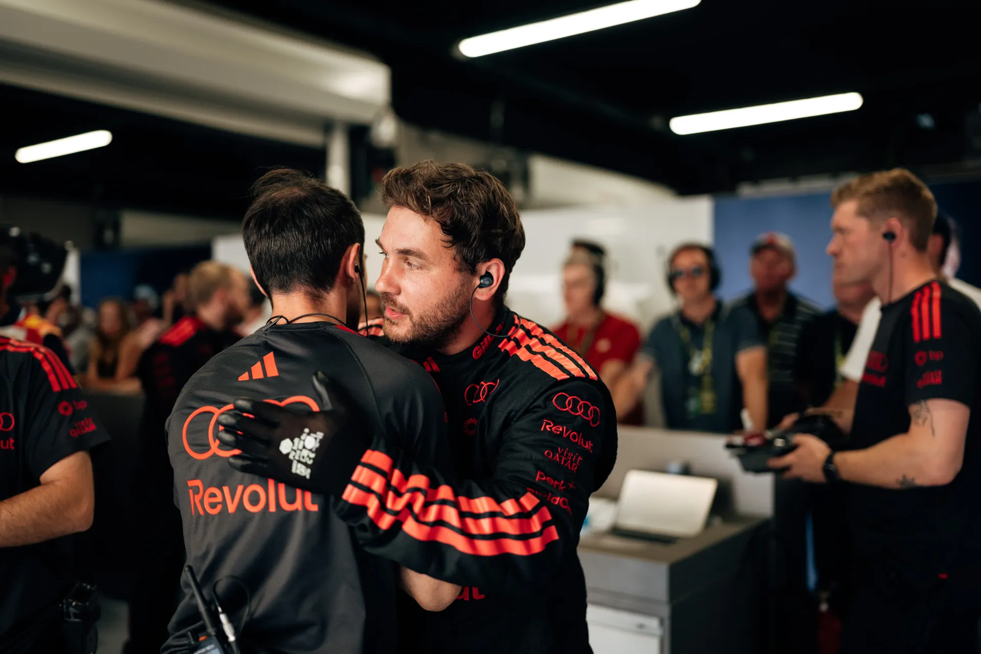 Audi Revolut F1® Team engineers embracing inside the garage after a session, showing team support and coordination during the Barcelona Grand Prix weekend
