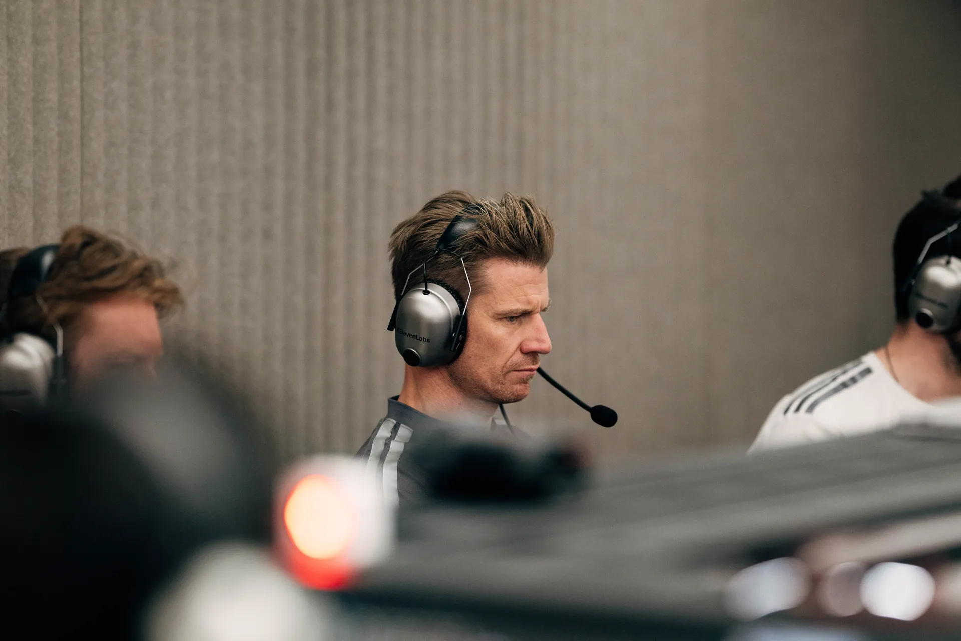 Audi Revolut F1® Team driver Nico Hulkenberg wearing a headset, focused on live data analysis during qualifying inside the Barcelona garage