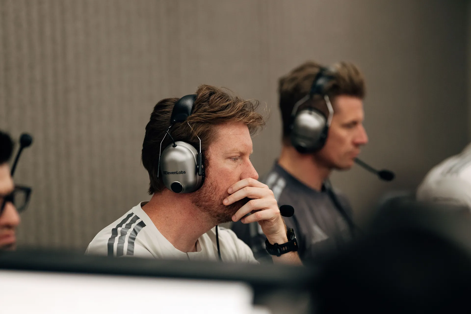 Audi Revolut F1® Team engineers wearing headsets, monitoring telemetry and discussing performance data during qualifying session