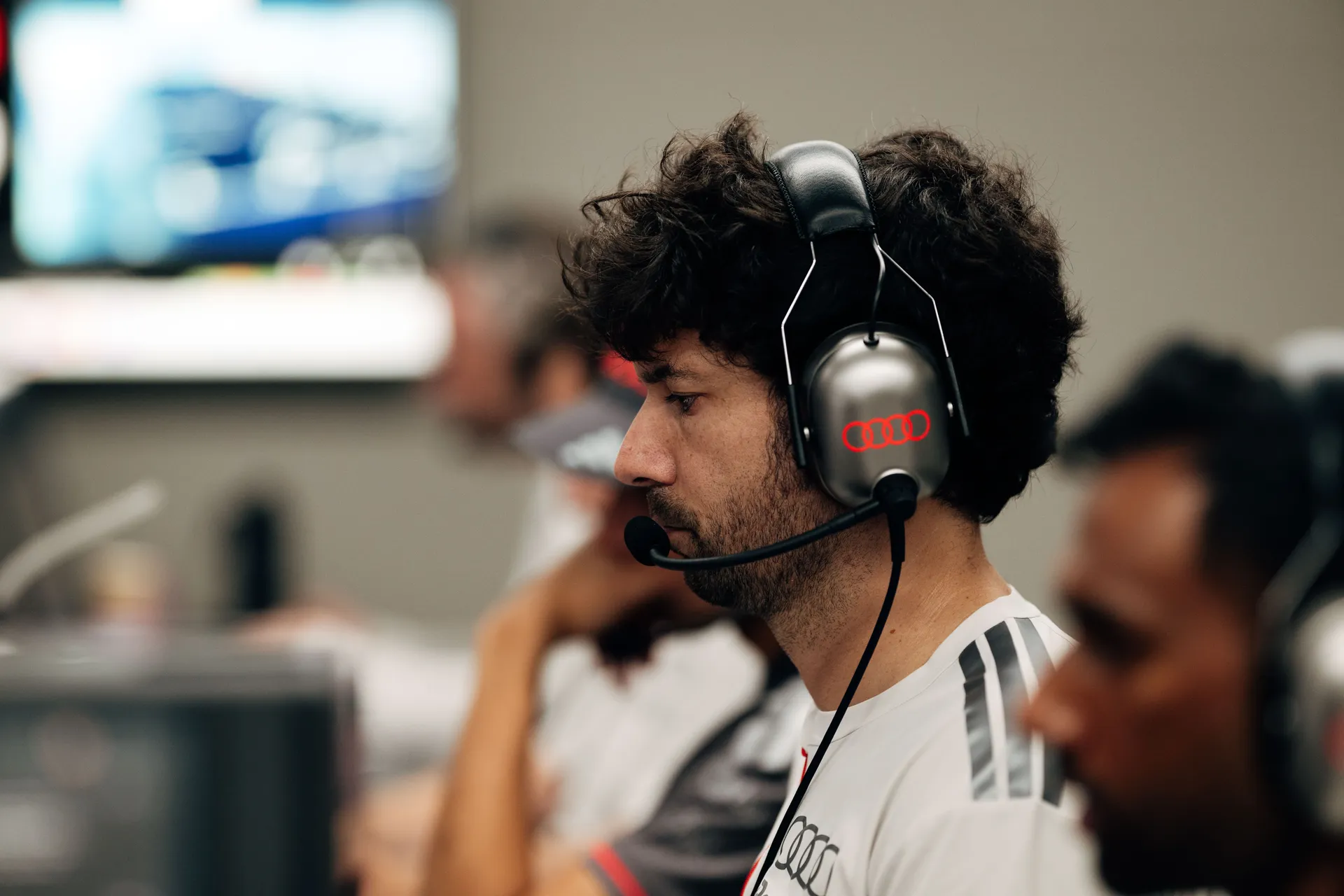 Audi Revolut F1® Team engineer with headset concentrating on live timing screens and telemetry inside the Barcelona garage during qualifying