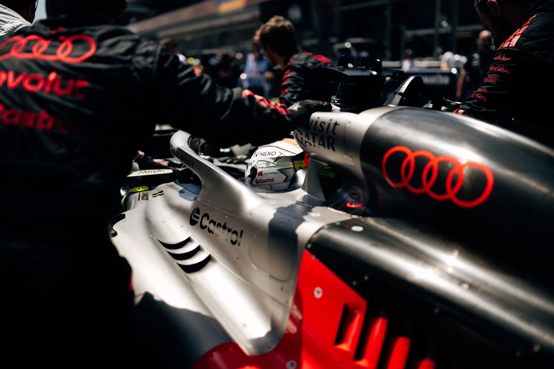 Close-up of the Audi R26 cockpit as Audi Revolut F1® Team mechanics assist the driver during final grid preparations.