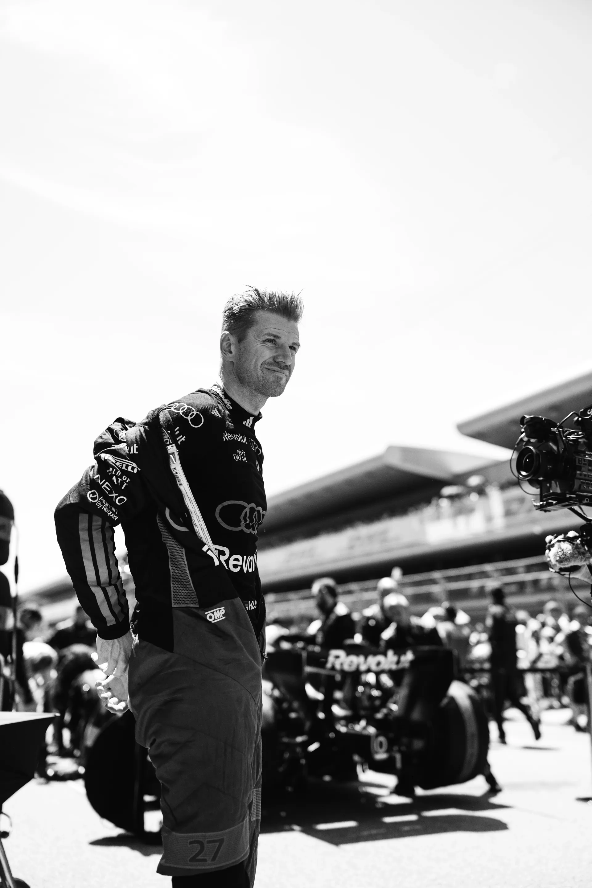 Nico Hulkenberg standing on the grid focused ahead of the race, with the Audi R26 behind him.