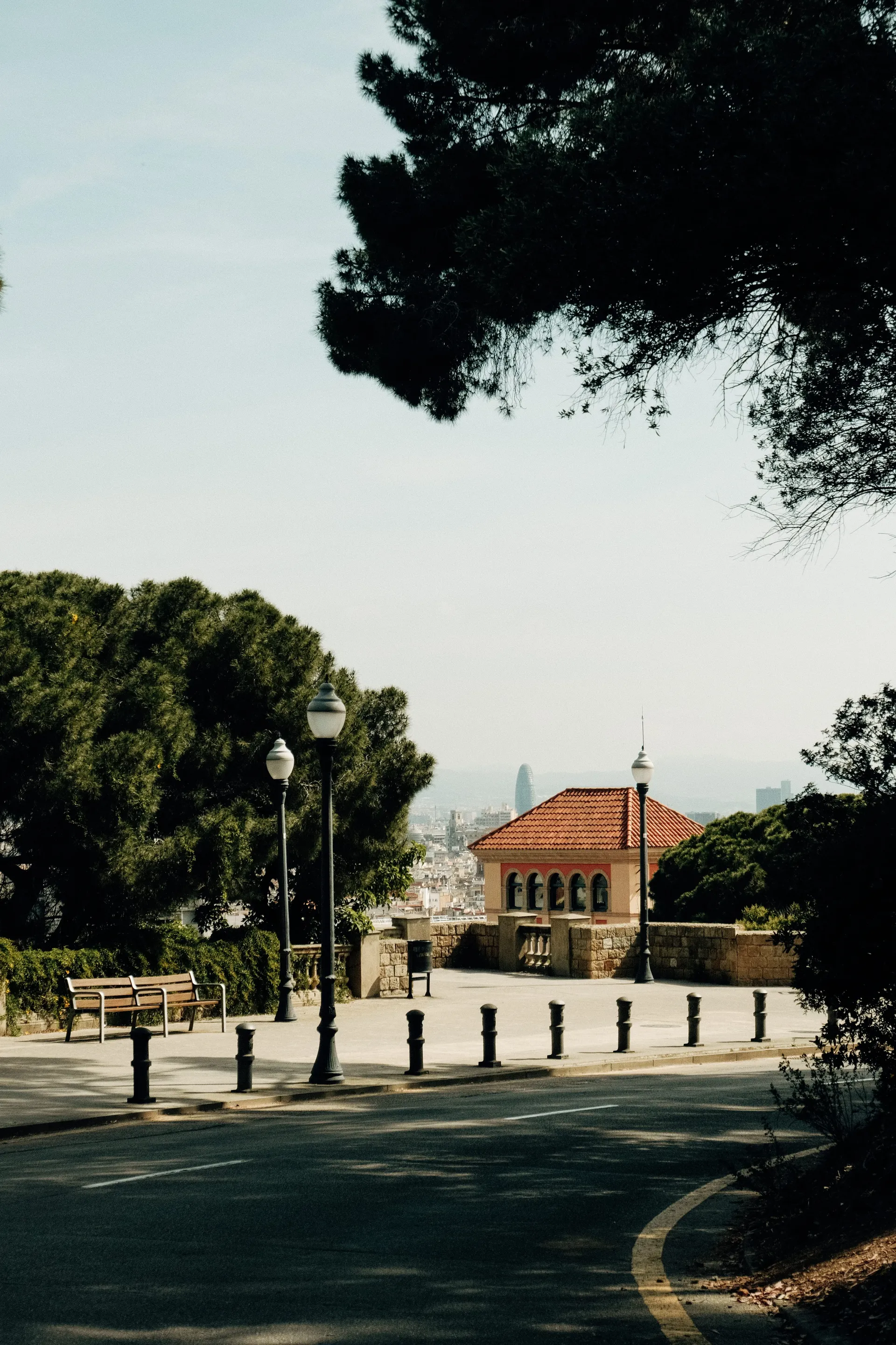 Road bend on Montjuïc in Barcelona with park benches and a view over the city