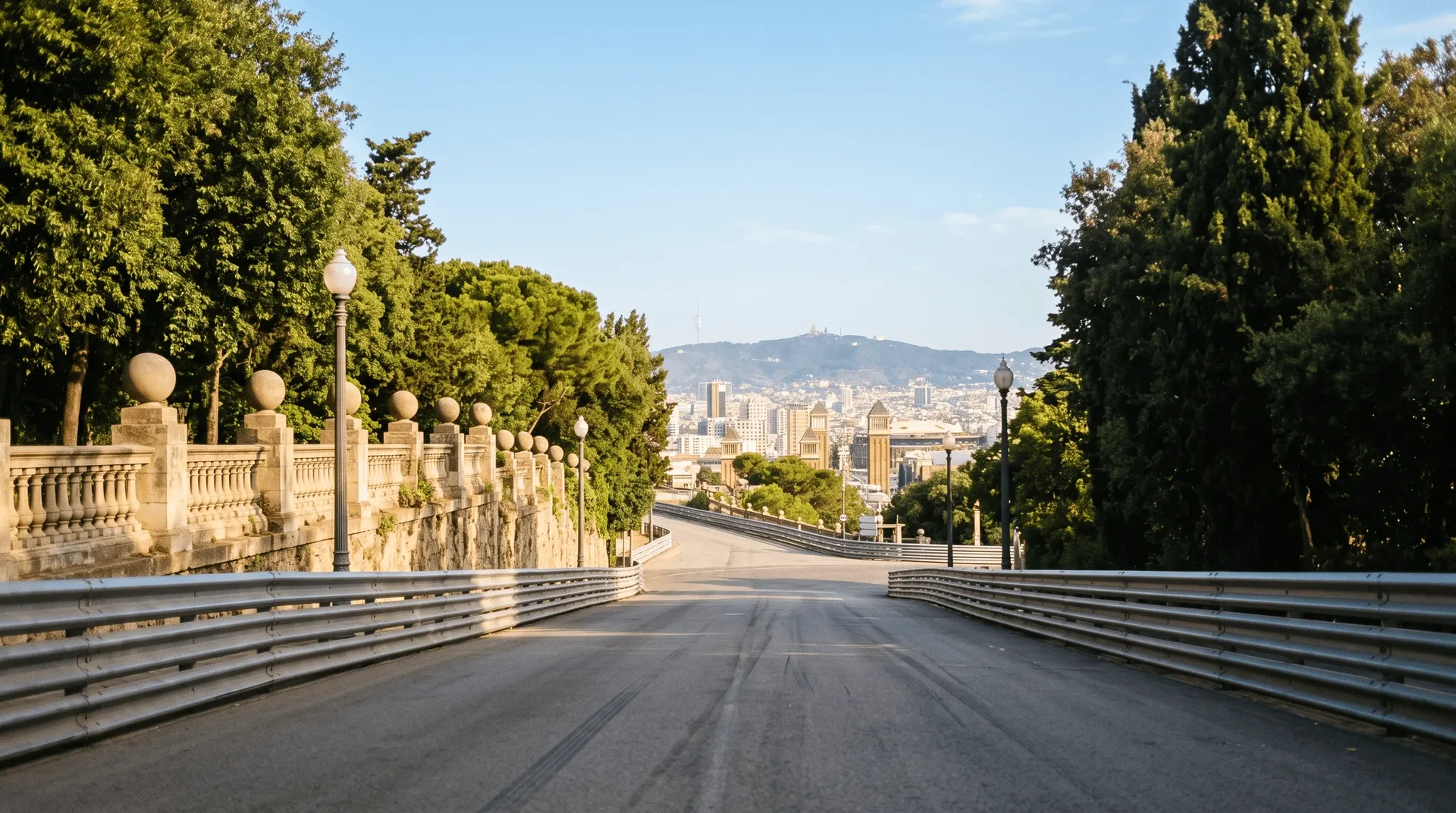 Empty road on Montjuïc in Barcelona with guardrails and a view over the city towards Tibidabo