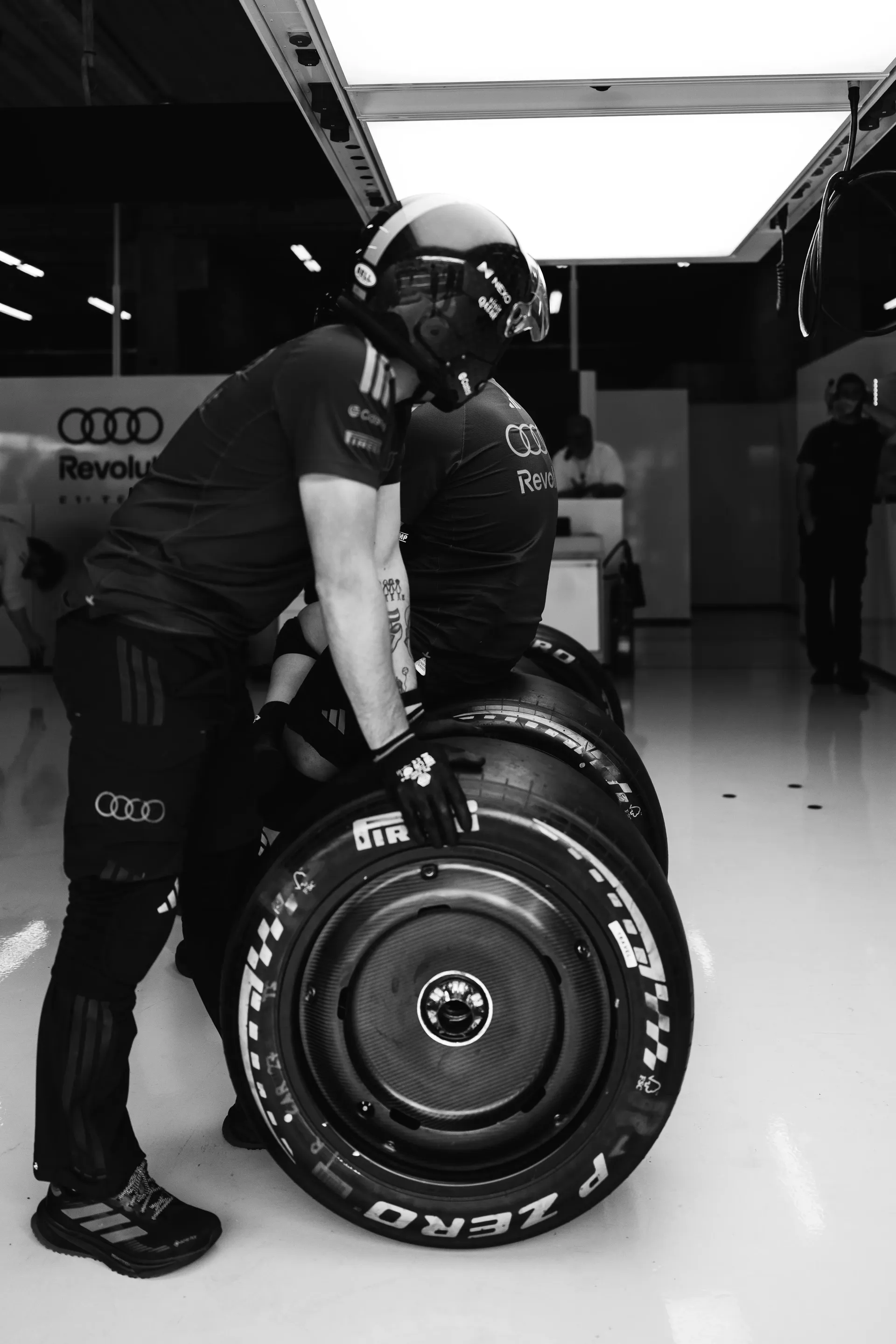 Audi Revolut F1® Team mechanics move tyres inside the garage during preparations for the Belgian Grand Prix session.