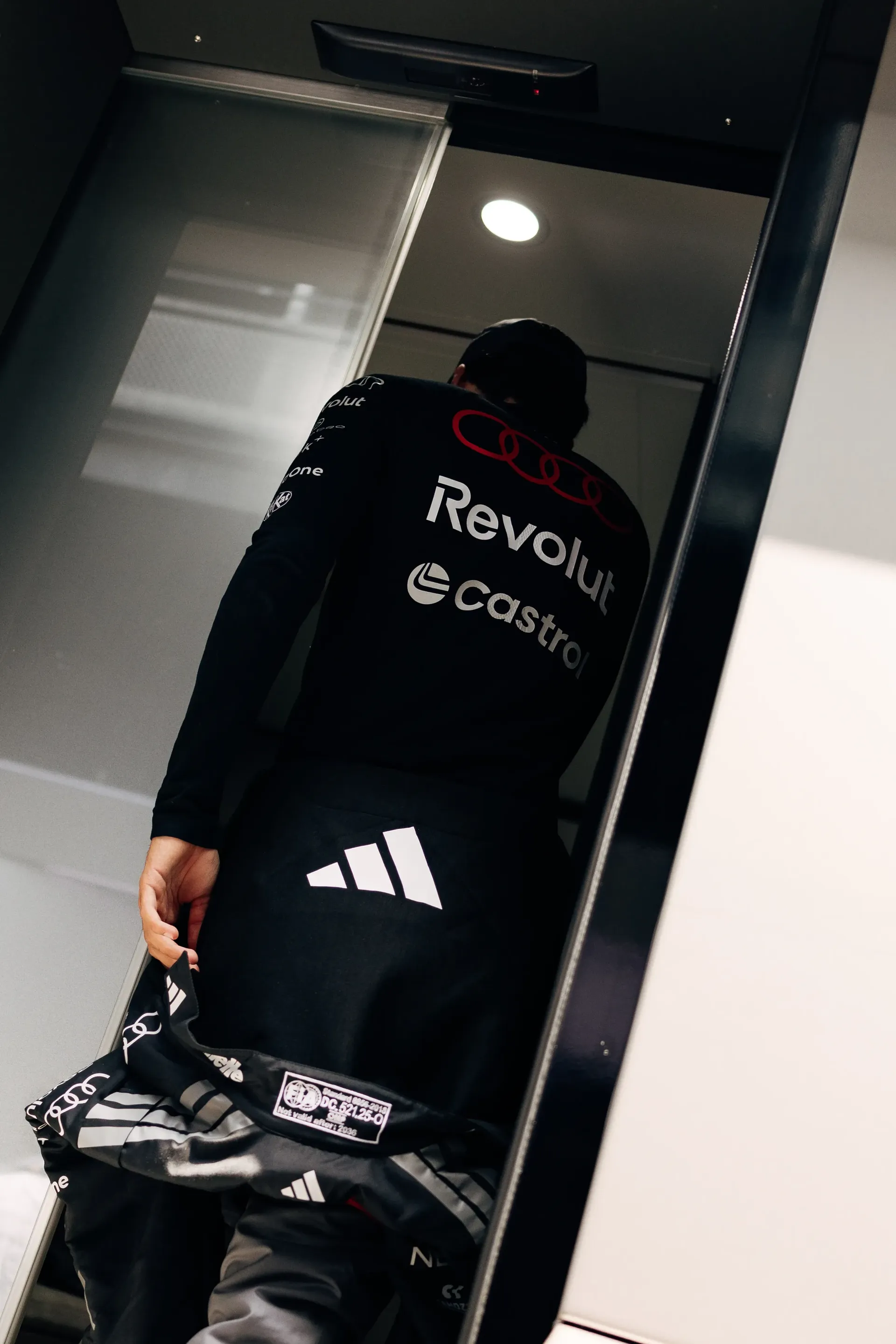 Gabriel Bortoleto walks into the garage area in full race kit, preparing to join the session with Audi Revolut F1® Team.