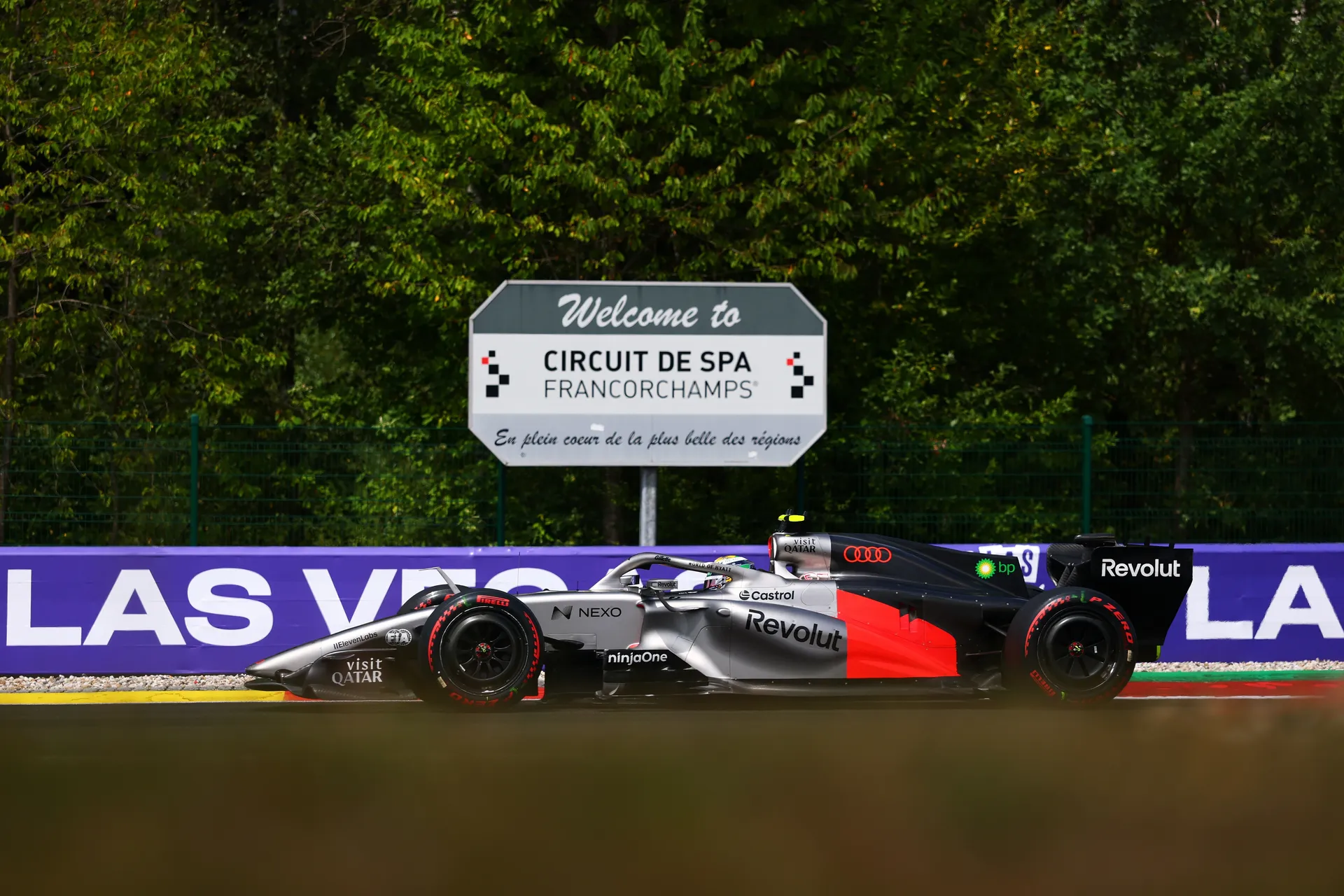 Audi R26 of Audi Revolut F1® Team passing the Circuit de Spa Francorchamps sign with forest backdrop
