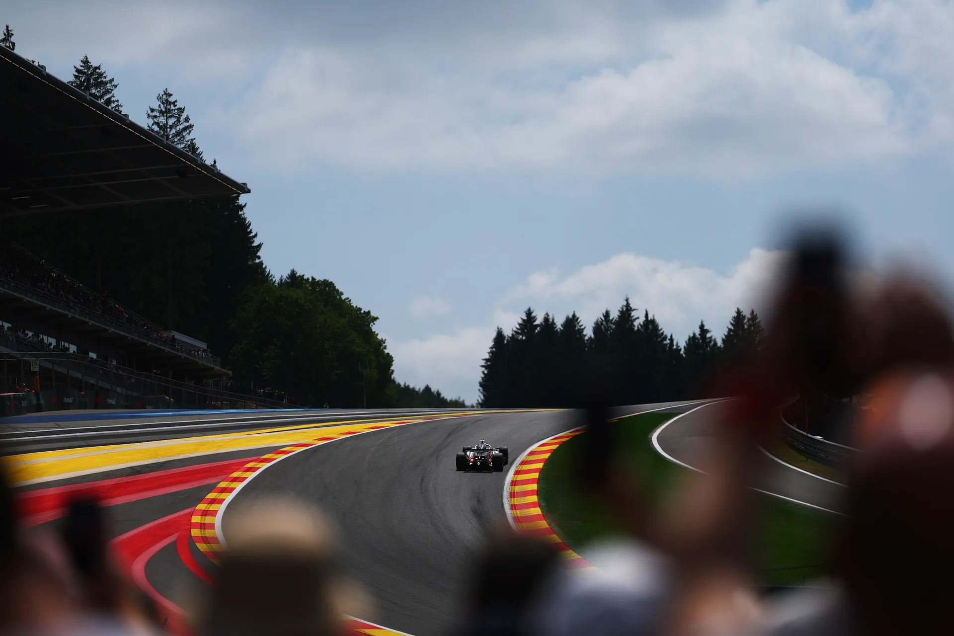 Audi R26 of Audi Revolut F1® Team climbing uphill at Spa with grandstands and forest in view