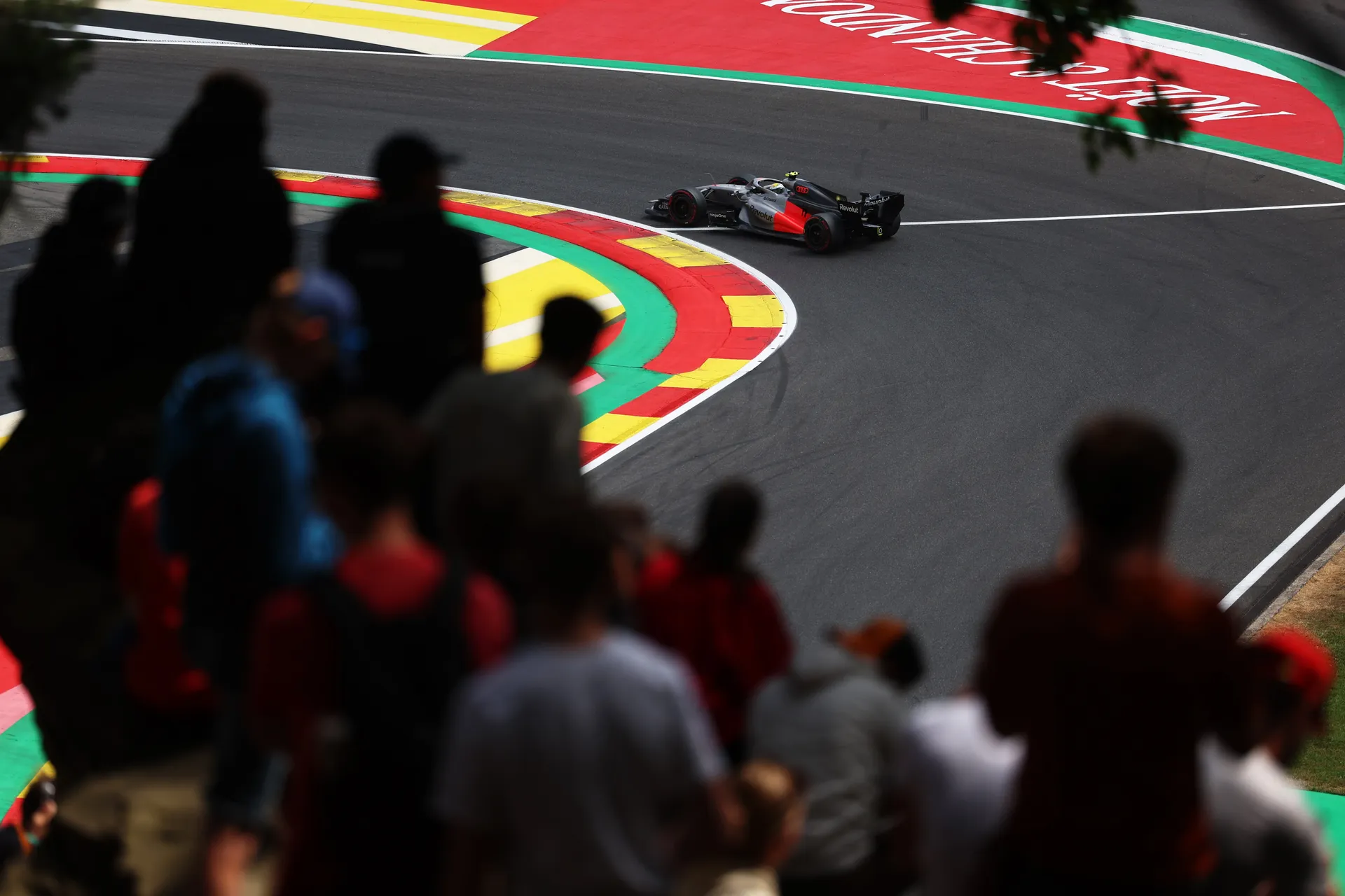 Audi R26 of Audi Revolut F1® Team taking a corner with spectators watching from the foreground