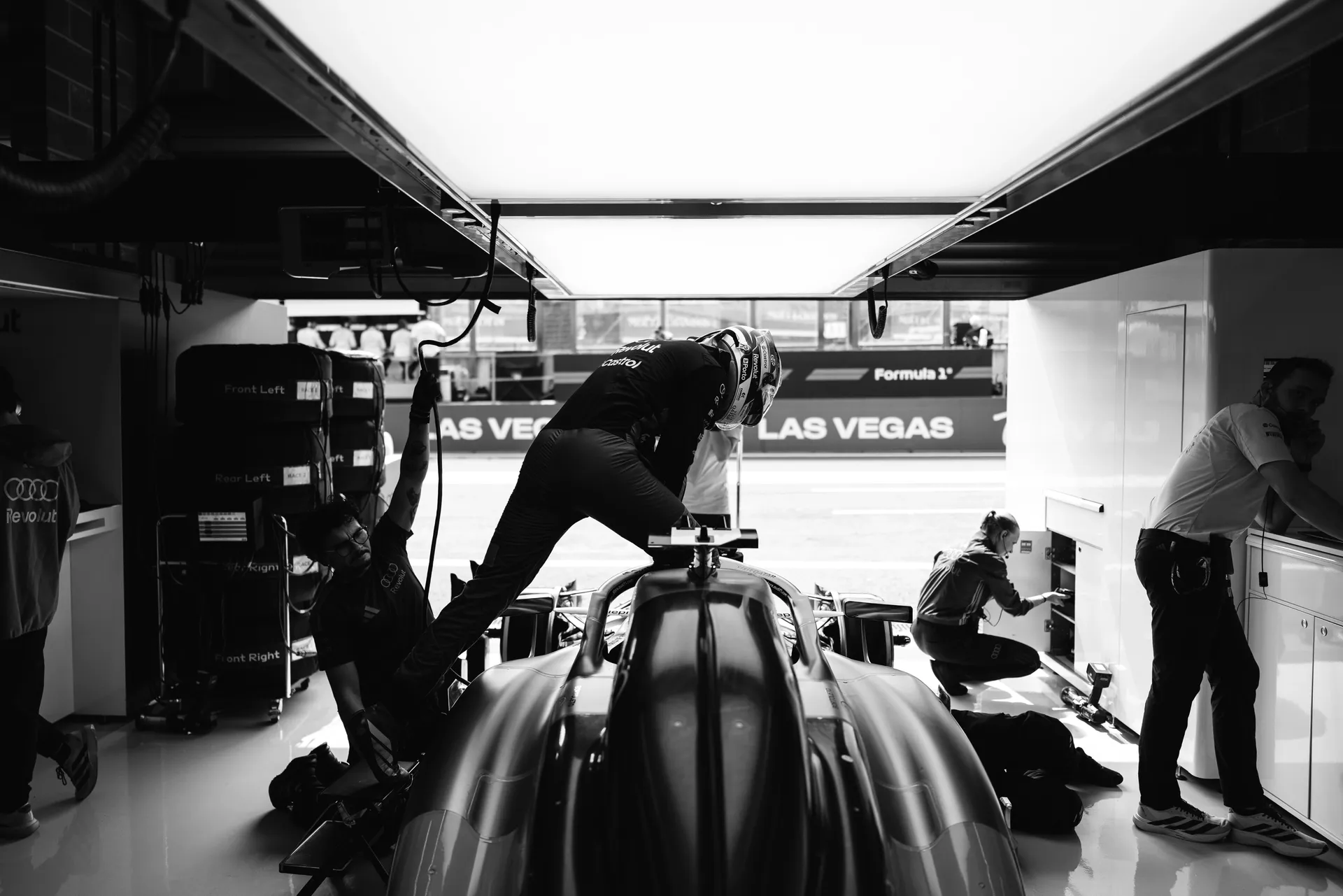 Driver climbs into the Audi R26 inside the garage as Audi Revolut F1® Team mechanics continue final preparations around the car