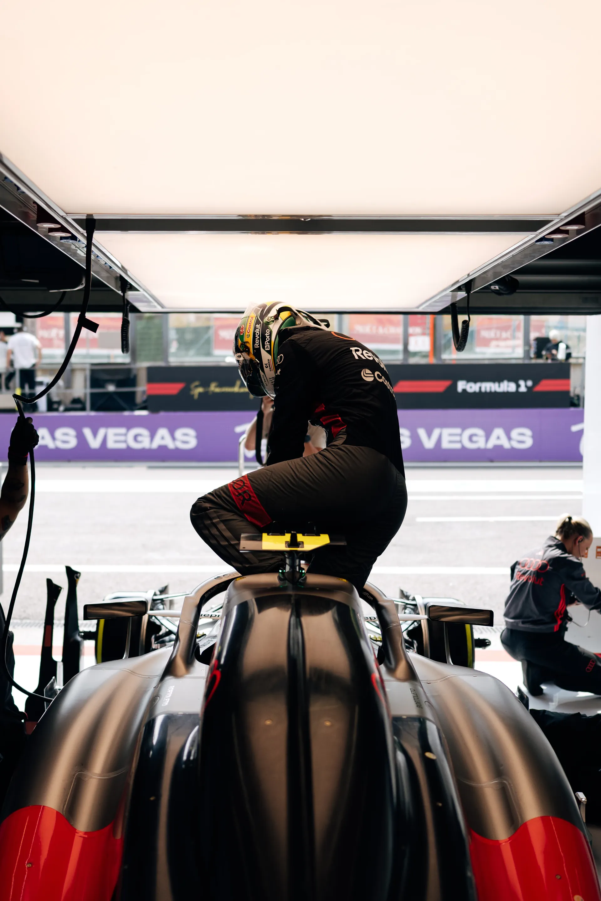 Gabriel Bortoleto seated on the Audi R26 cockpit during garage preparations, surrounded by Audi Revolut F1® Team crew ahead of qualifying