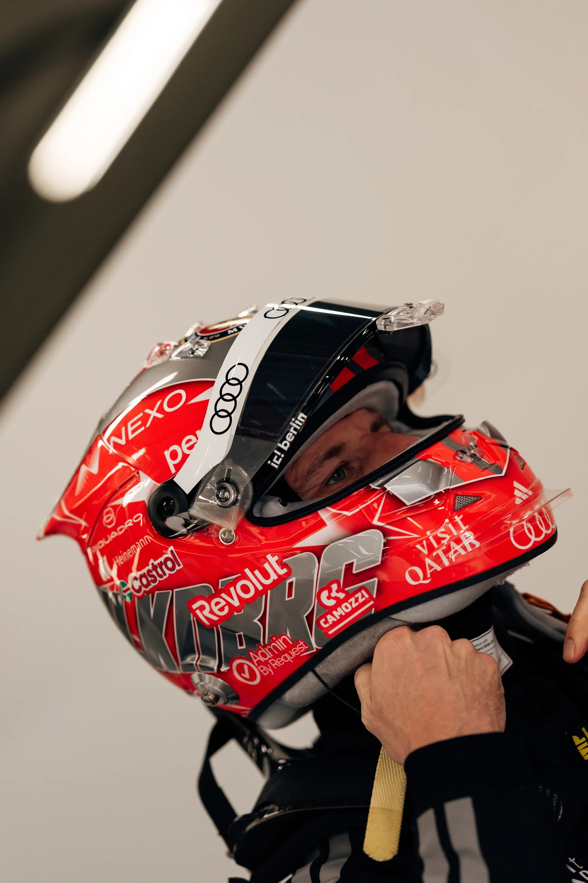 Close-up of Nico Hulkenberg helmet as he secures the strap before qualifying, wearing full Audi Revolut F1® Team race gear