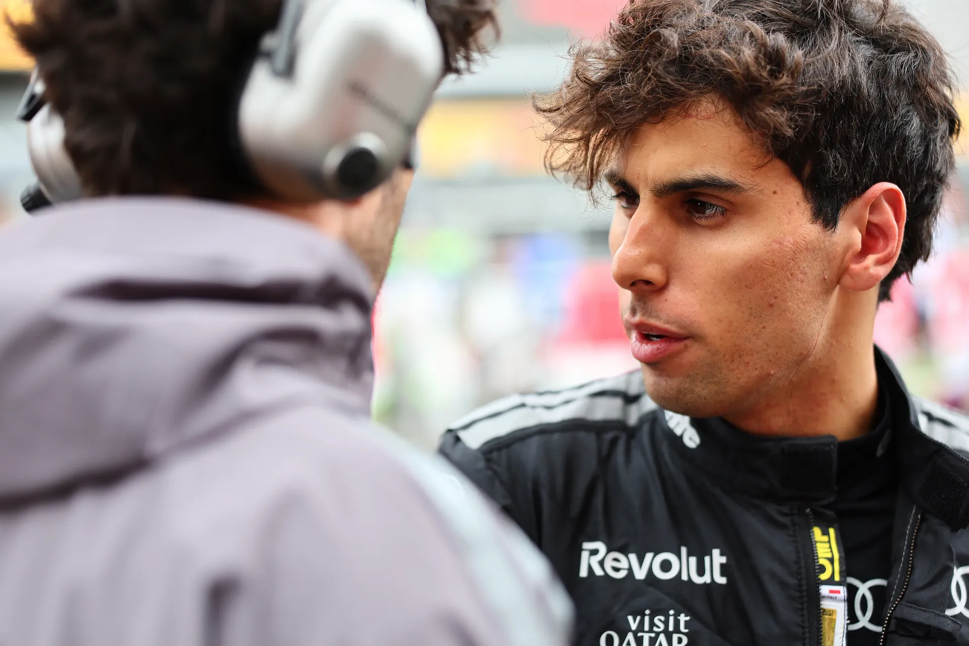 Gabriel Bortoleto speaks closely with an Audi Revolut F1® Team engineer during a focused pre-race discussion.