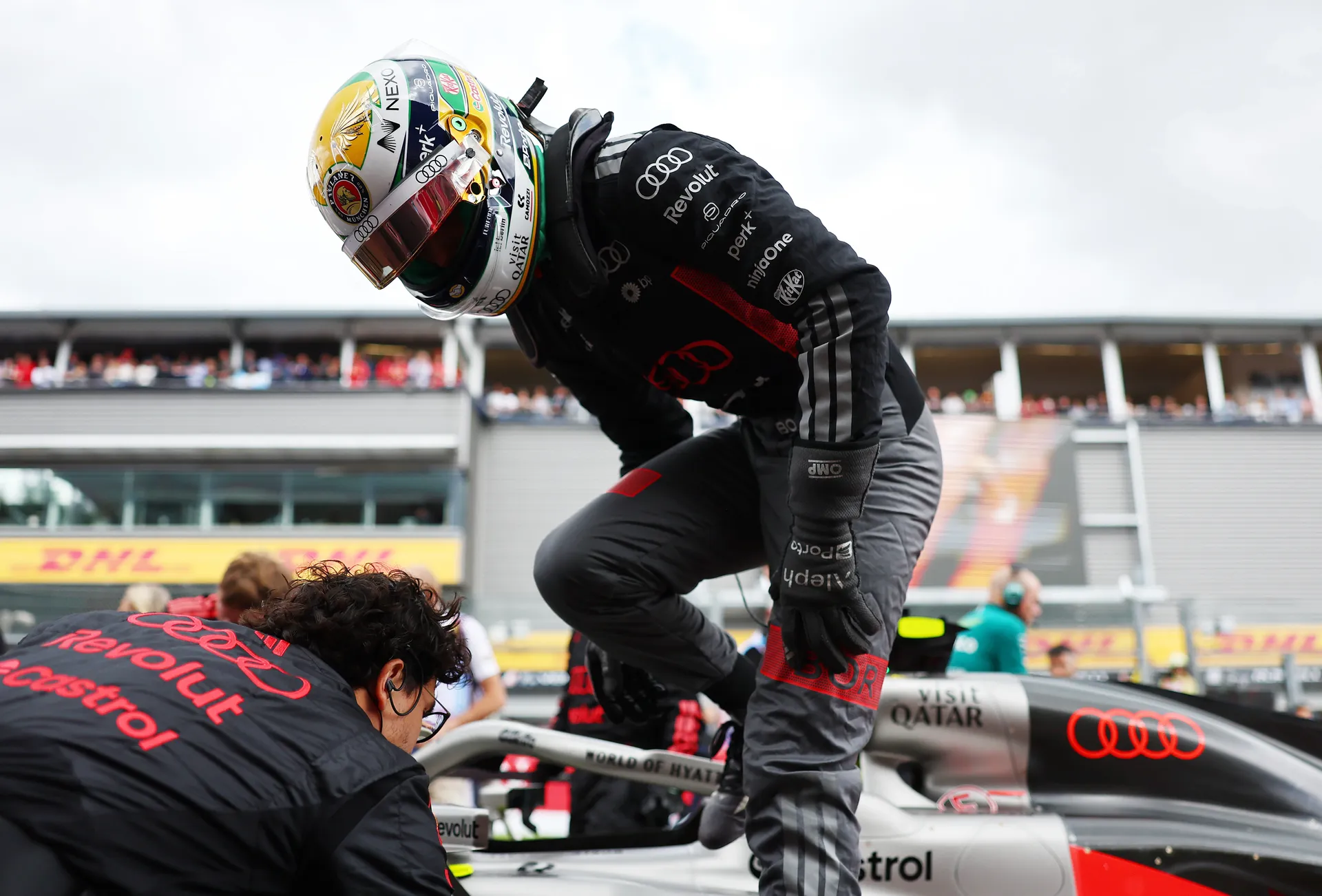 Gabriel Bortoleto climbs into the Audi R26 cockpit with assistance from an Audi Revolut F1® Team mechanic on the grid.
