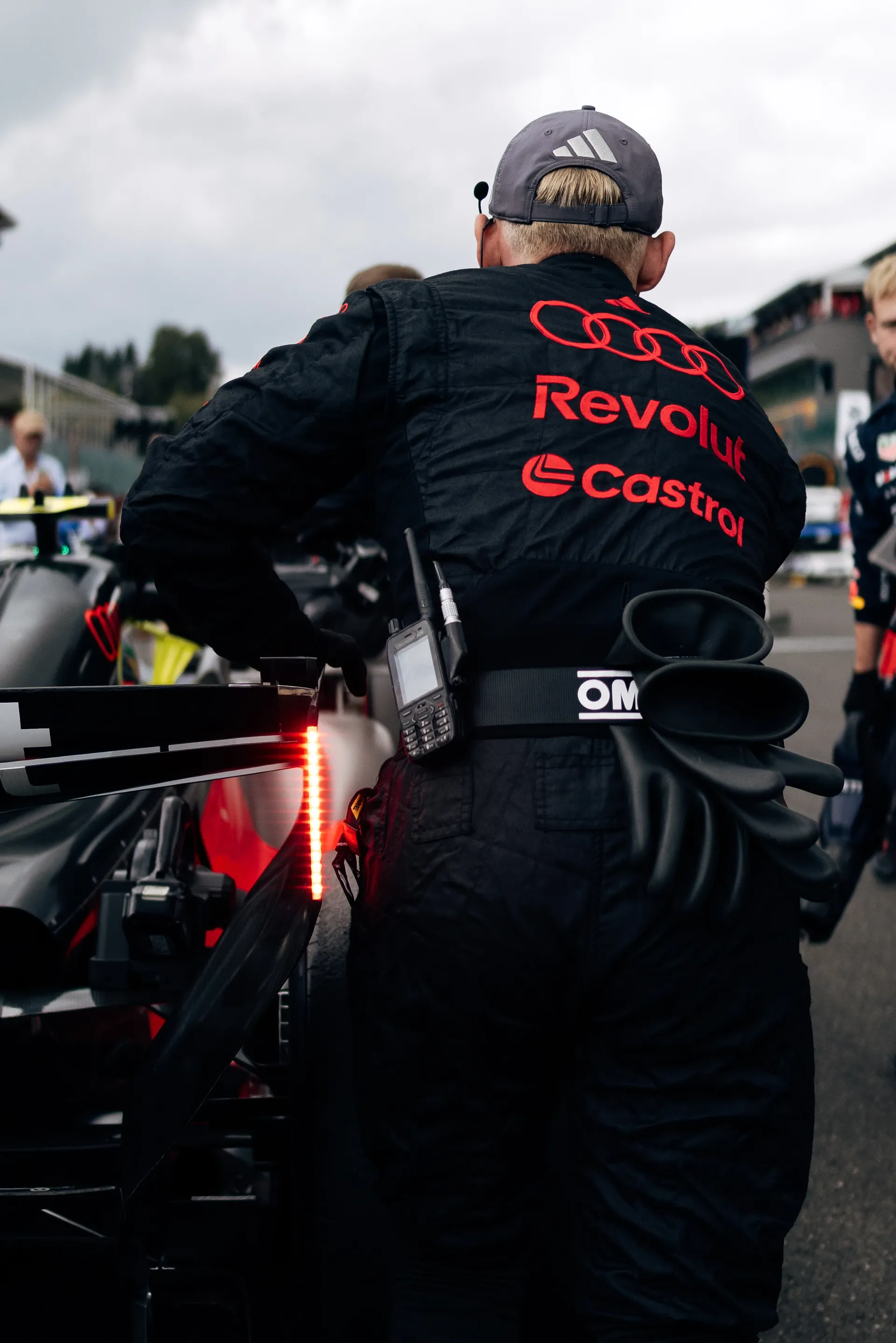 Audi Revolut F1® Team mechanic pushes the car on the grid with the rear rain light illuminated at Spa-Francorchamps.