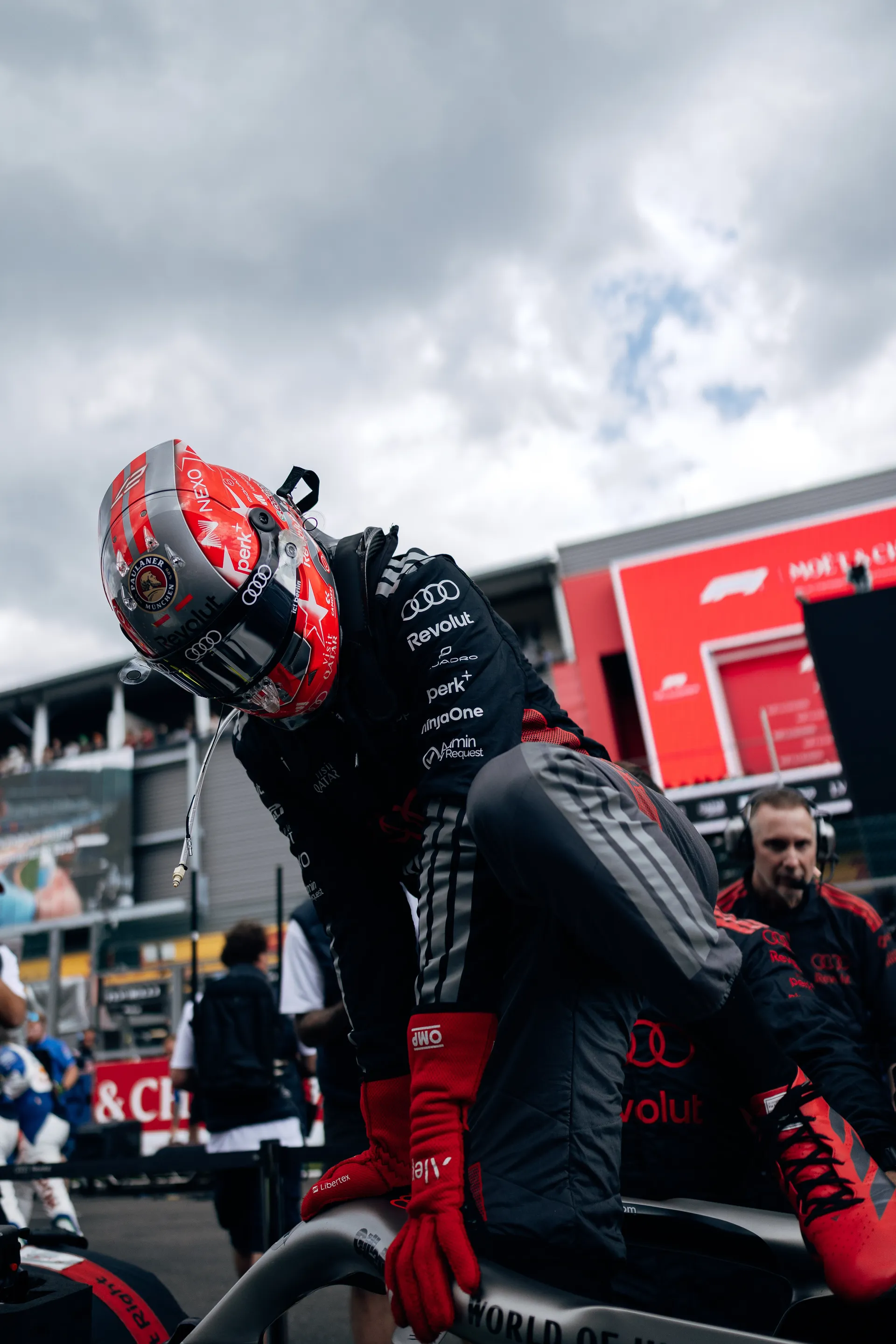 Nico Hulkenberg climbs into the Audi Revolut F1® Team car during pre-race preparations on the grid at Spa-Francorchamps.