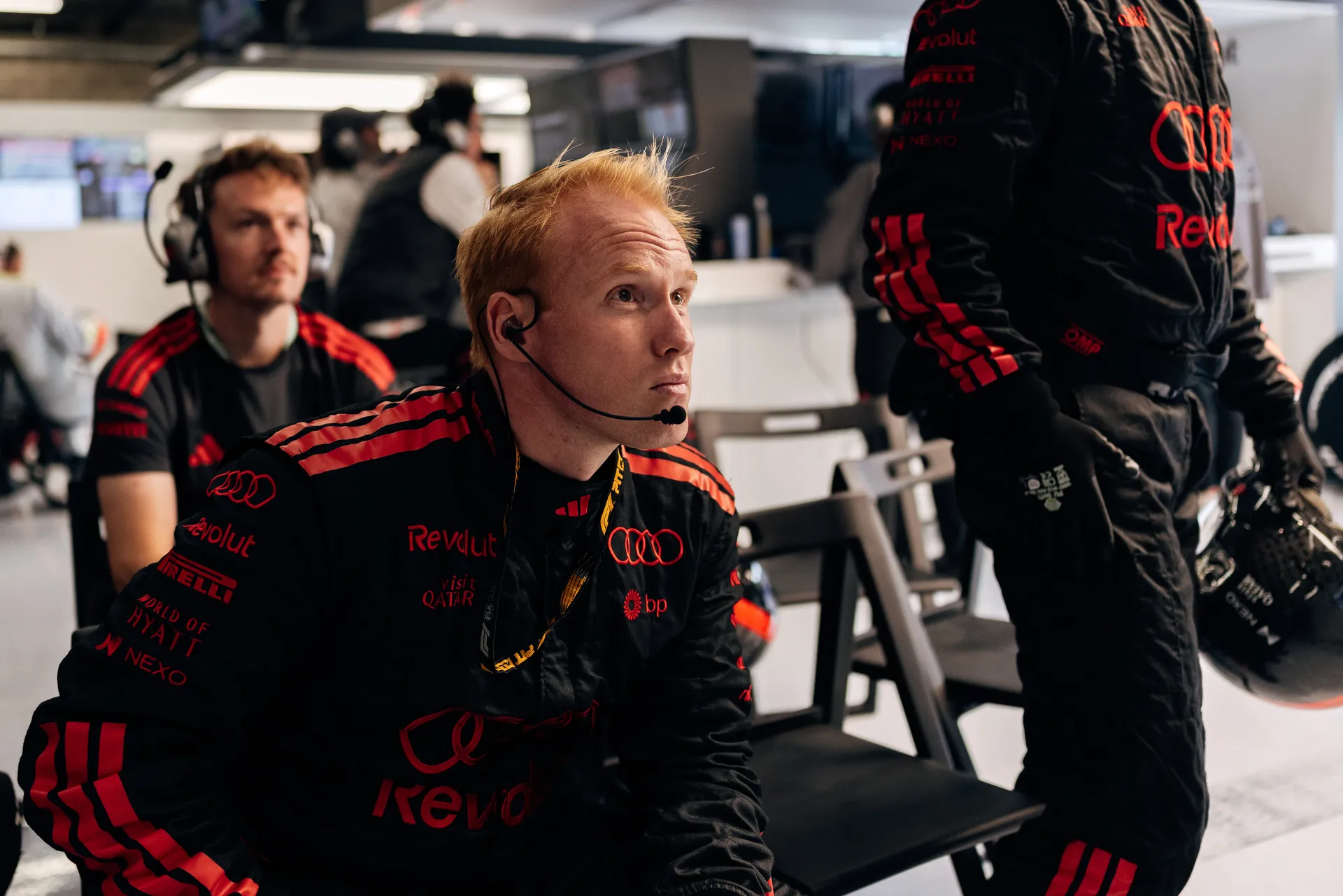 Two Audi Revolut F1® Team members walking in the pit lane with arms around each other in front of the garage during the race weekend