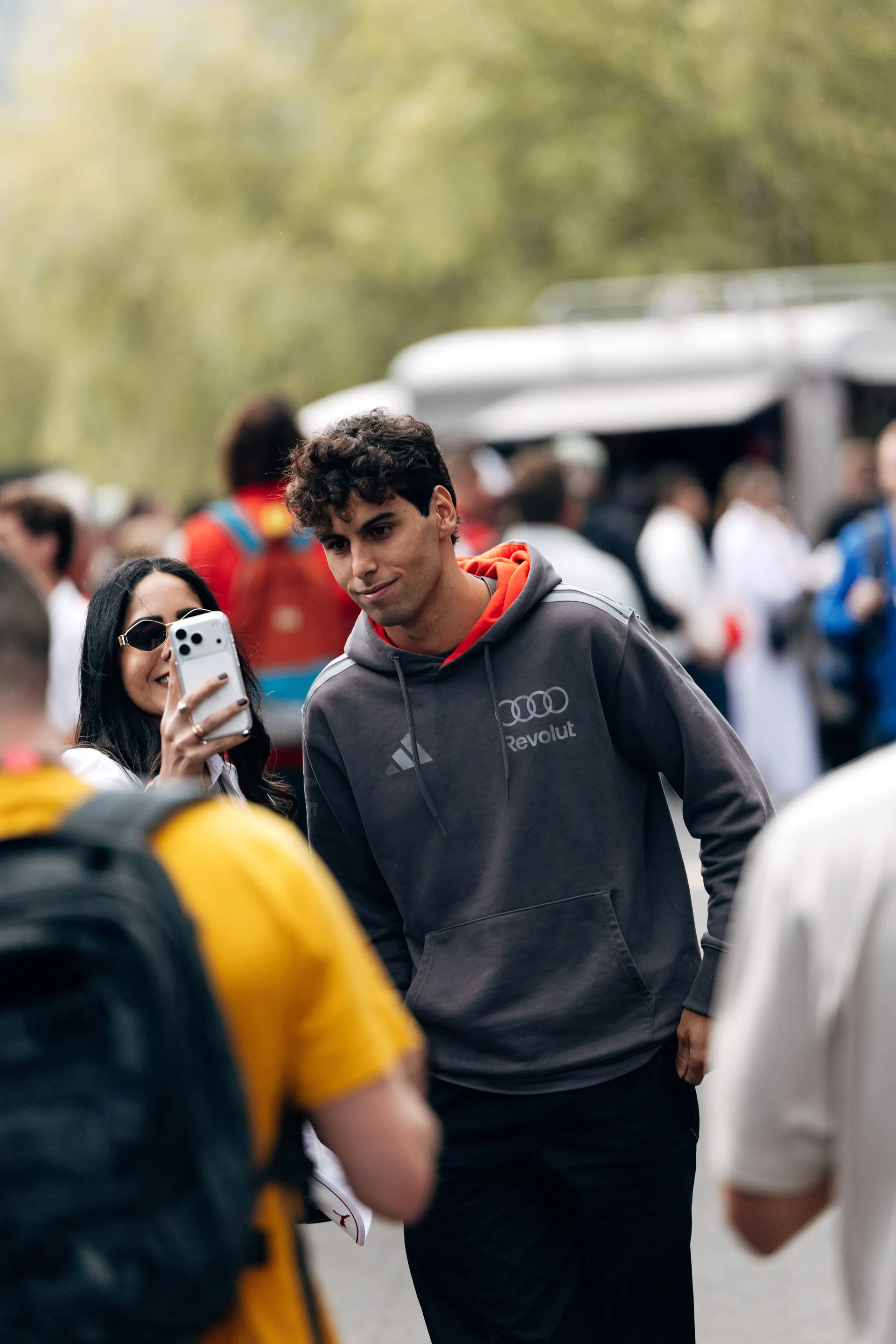 Gabriel Bortoleto of Audi Revolut F1® Team stops to take a selfie with a fan in the paddock at Spa Francorchamps on Sunday