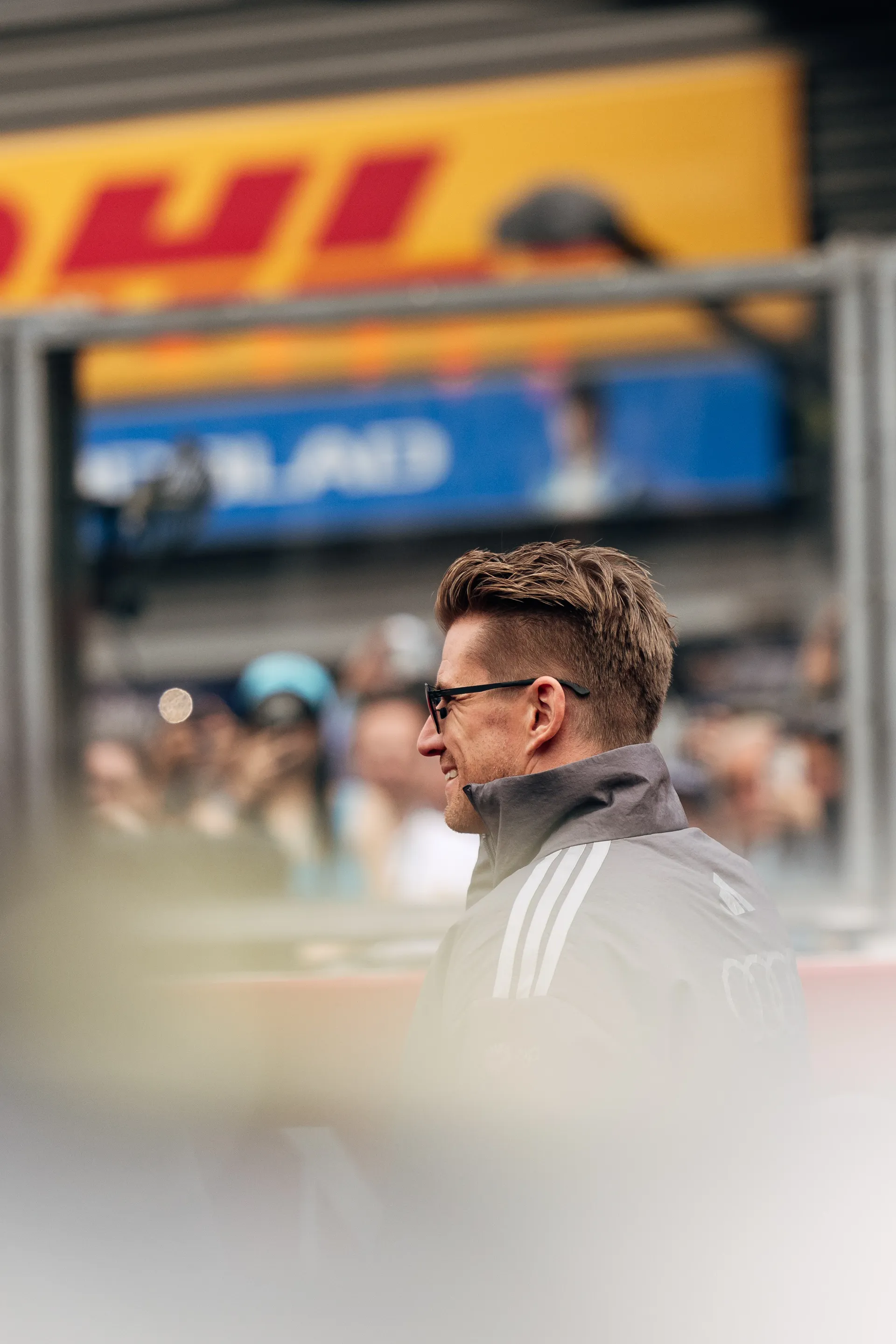 Nico Hulkenberg of Audi Revolut F1® Team smiles during the drivers parade at Spa Francorchamps with DHL branding visible in the background
