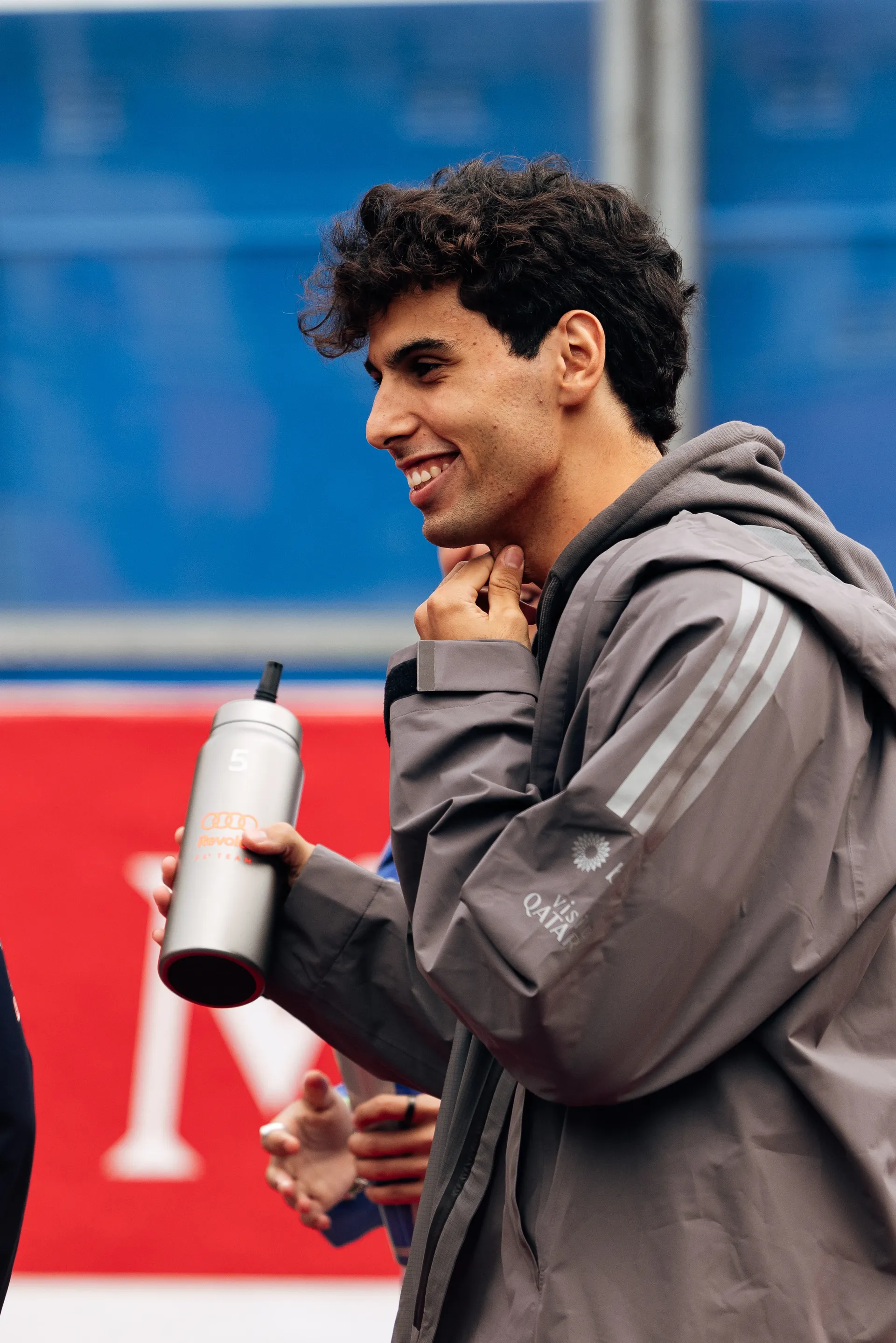 Gabriel Bortoleto of Audi Revolut F1® Team smiles while holding a team bottle during the drivers parade at Spa Francorchamps