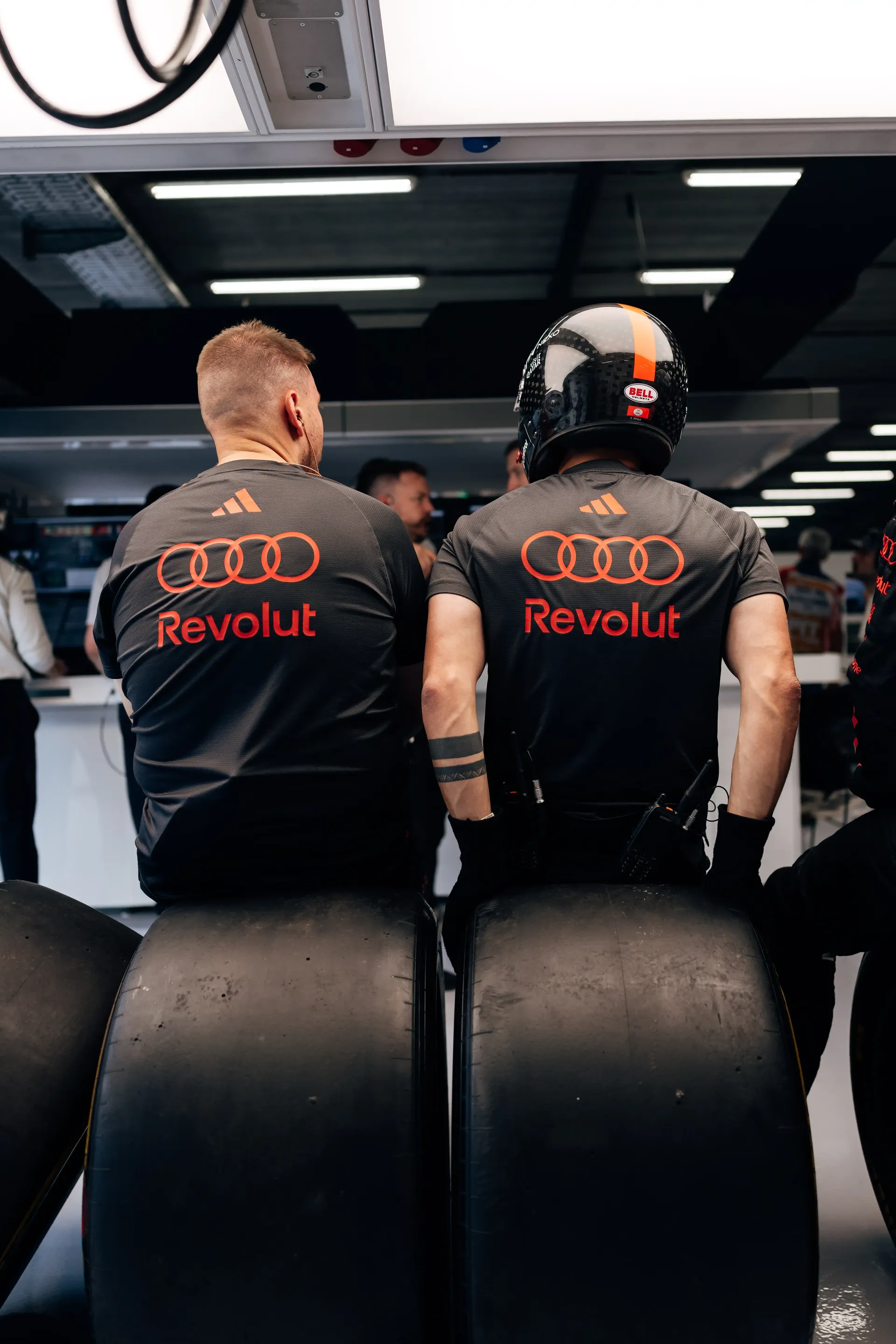Audi Revolut F1® Team mechanics stand beside fresh tyres inside the garage during FP2 at the 2026 Belgian Grand Prix in Spa-Francorchamps.